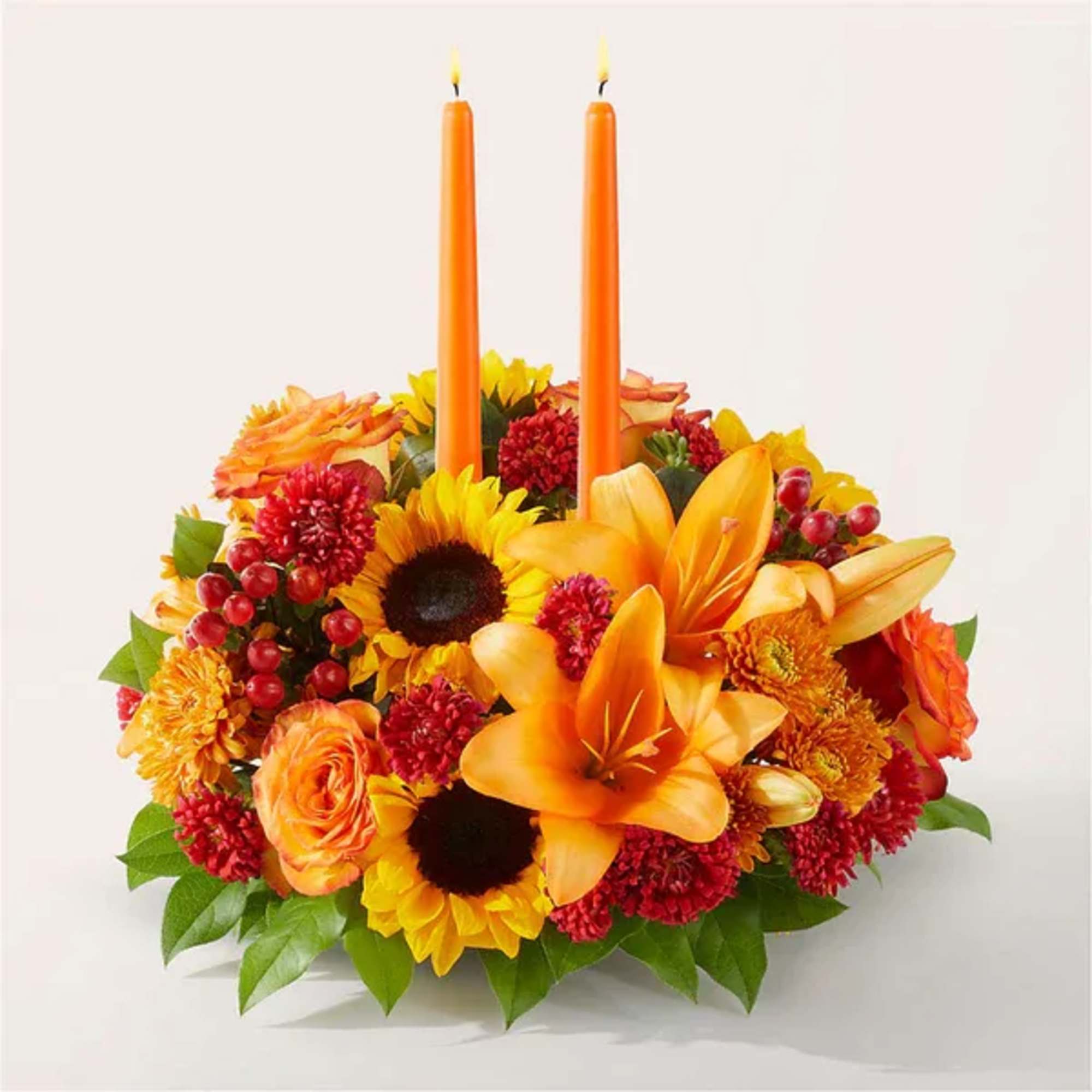 Orange floral centerpiece with two orange candles