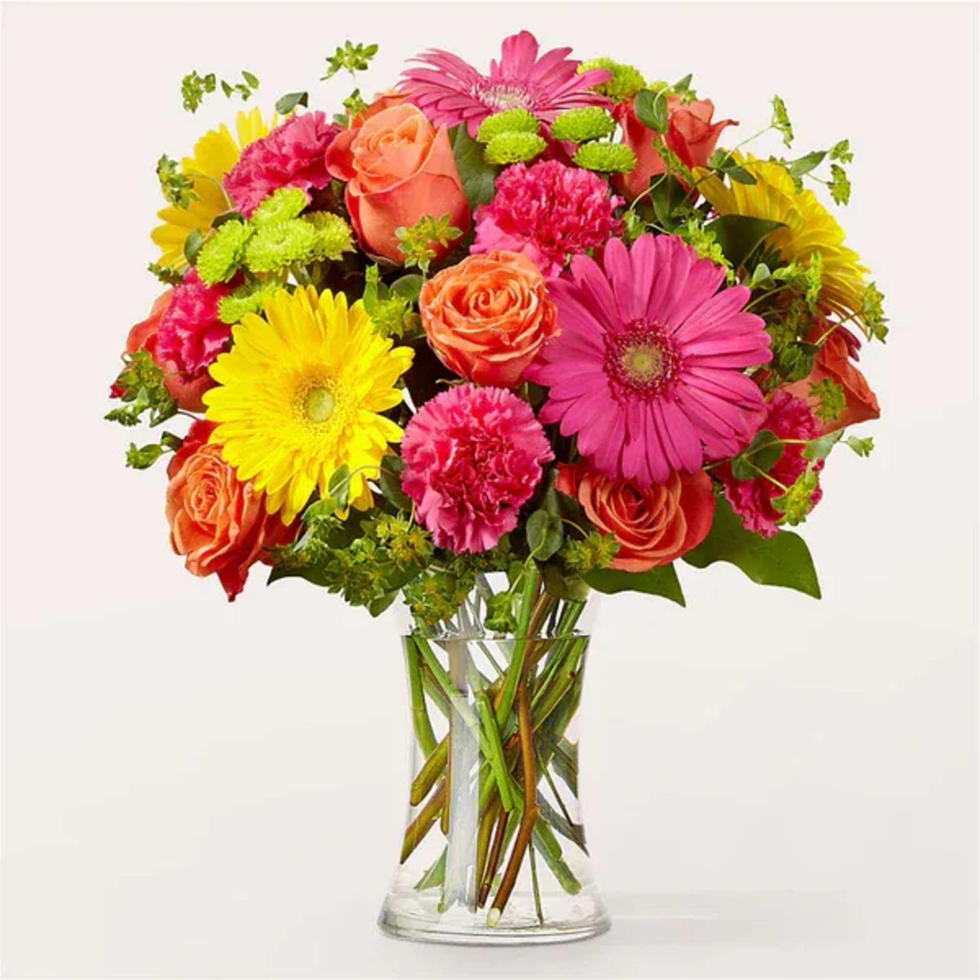 Bright mixed bouquet of roses, gerbera daisies, and carnations in a clear glass vase.