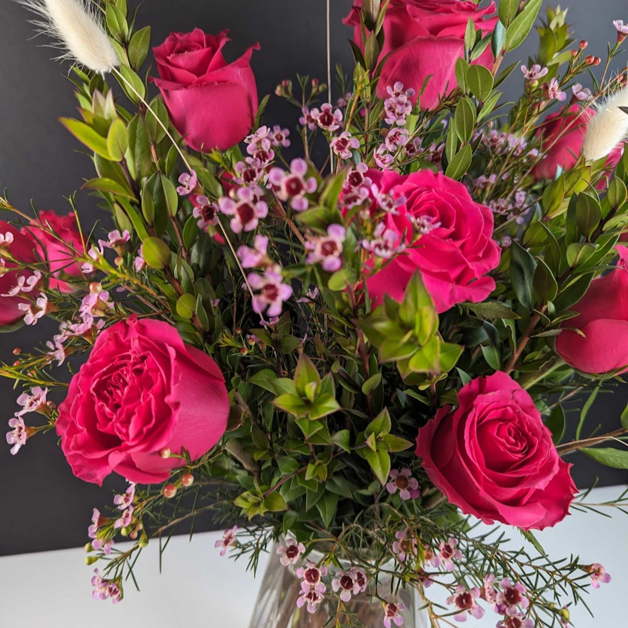 Hot pink roses with small pink filler flowers in a clear vase