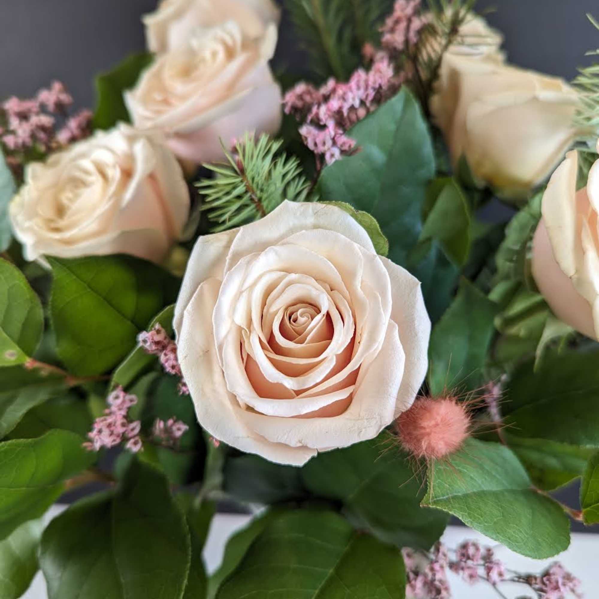 Bouquet of pale blush roses with pink filler flowers and greenery