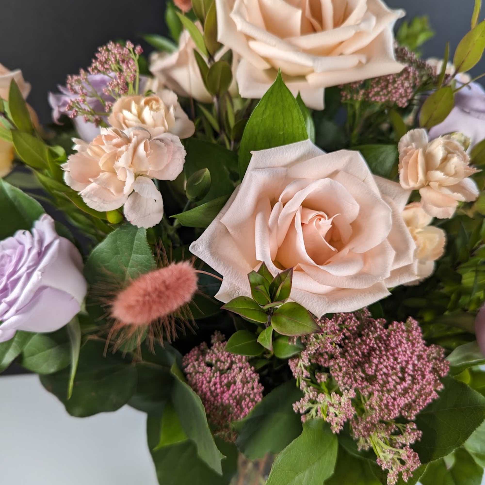 Bouquet of blush roses and pale pink carnations with greenery