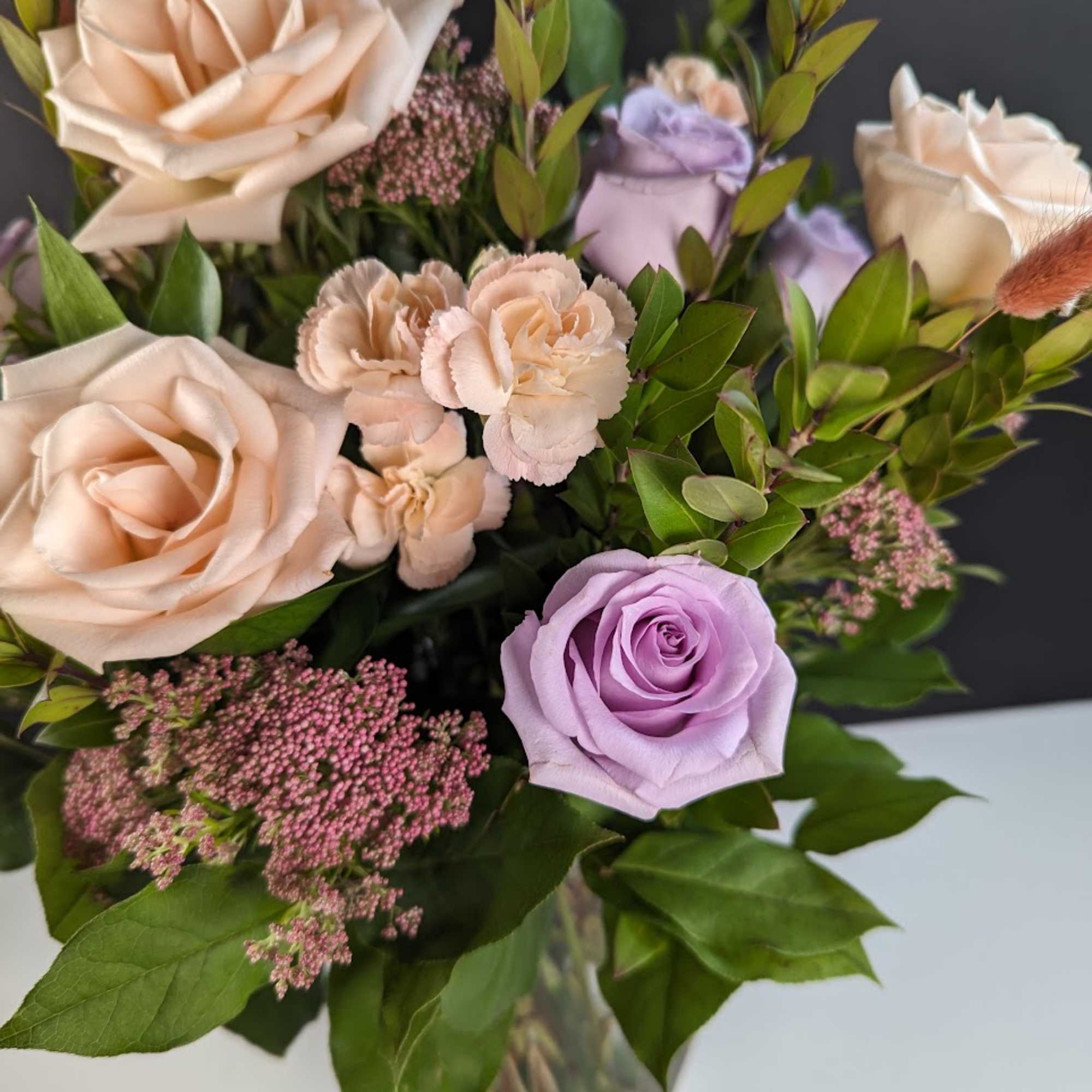 Bouquet of lavender and blush roses with pink filler flowers
