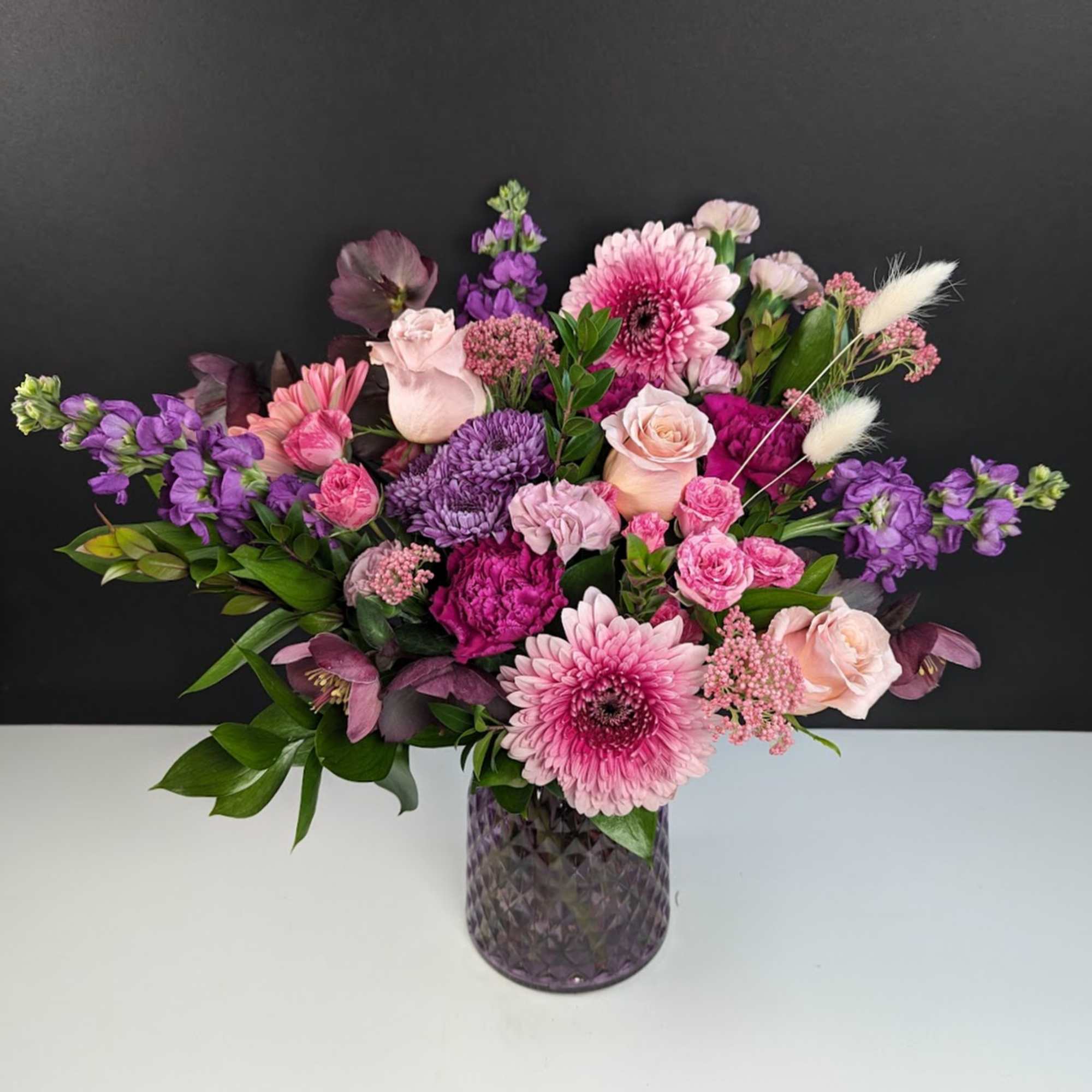 Pink and purple mixed bouquet in a textured glass vase