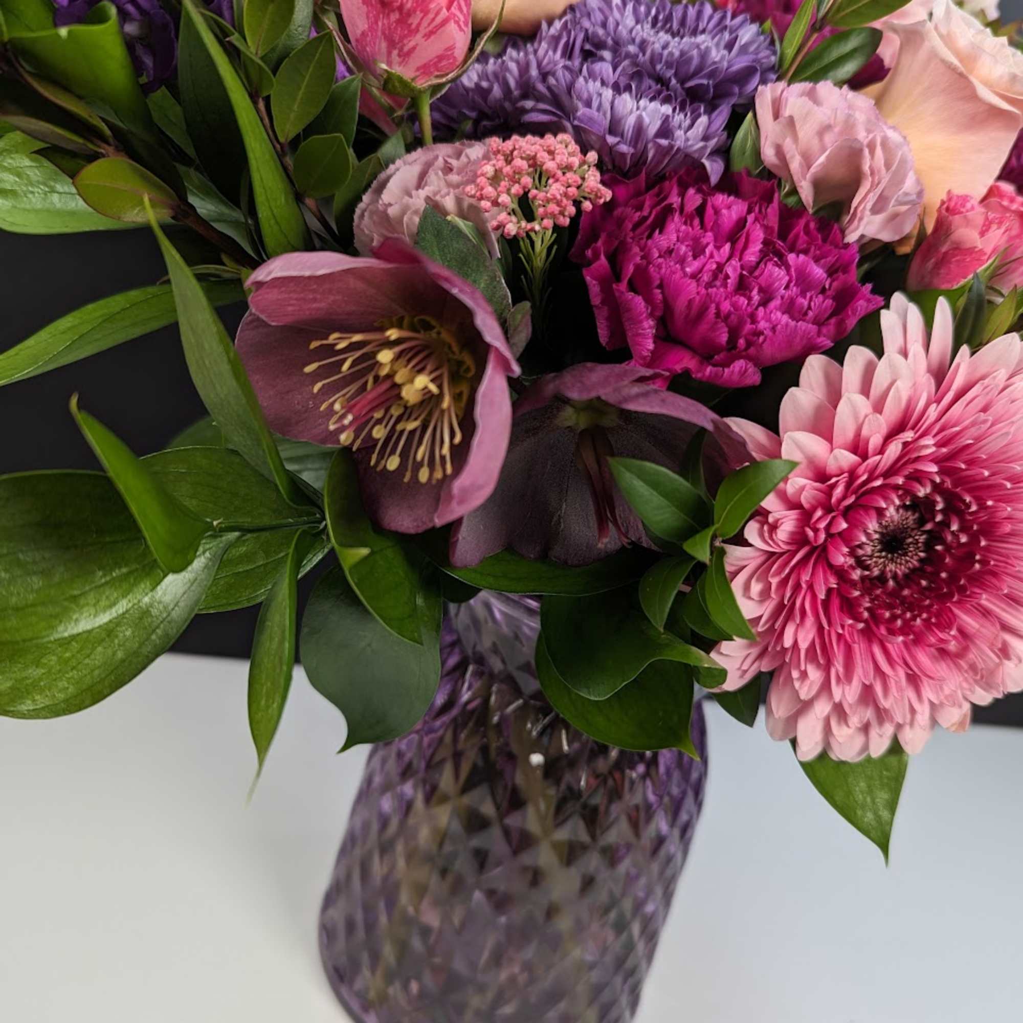 Pink and purple mixed bouquet in a faceted glass vase