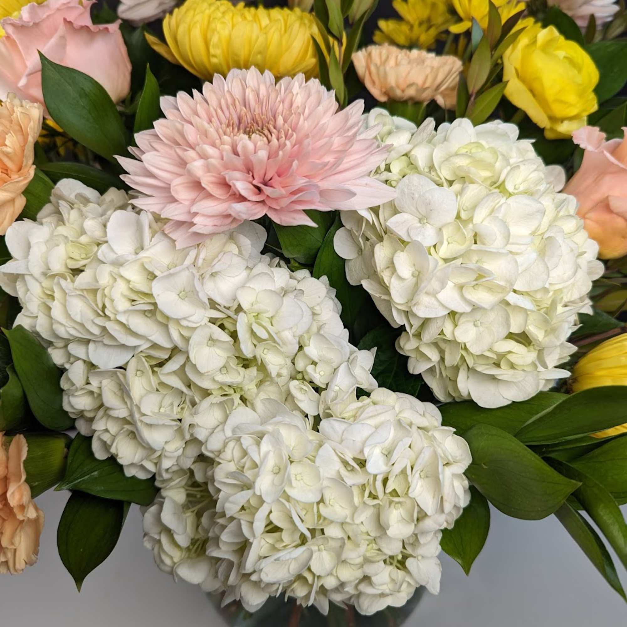 Bouquet of white hydrangeas, pink chrysanthemums, and yellow roses