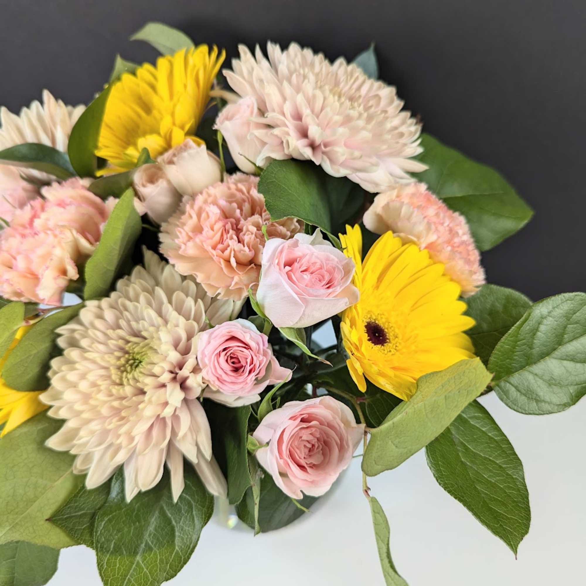 Bouquet of pink roses, yellow gerbera daisies, and pale chrysanthemums