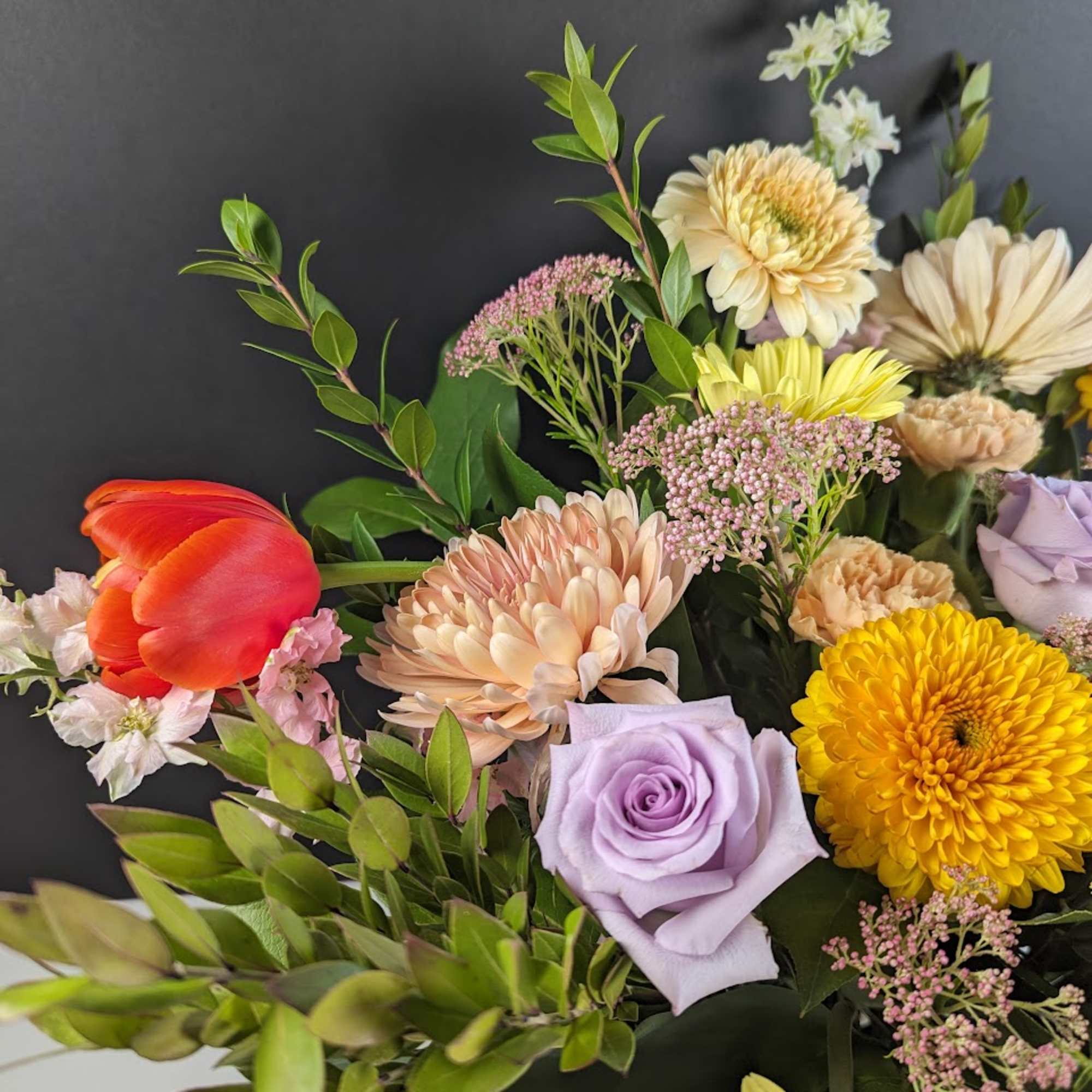 Mixed bouquet with tulips, roses, and chrysanthemums in pastel and bright colors