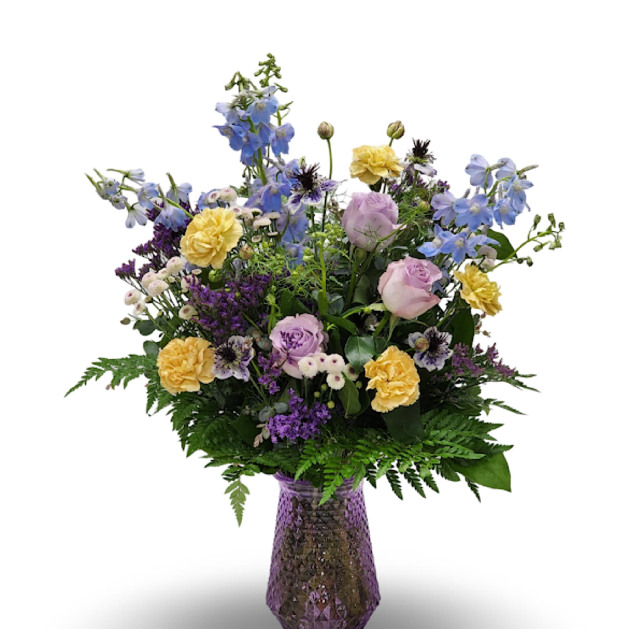 Mixed bouquet of blue, yellow, and lavender flowers in a purple vase.
