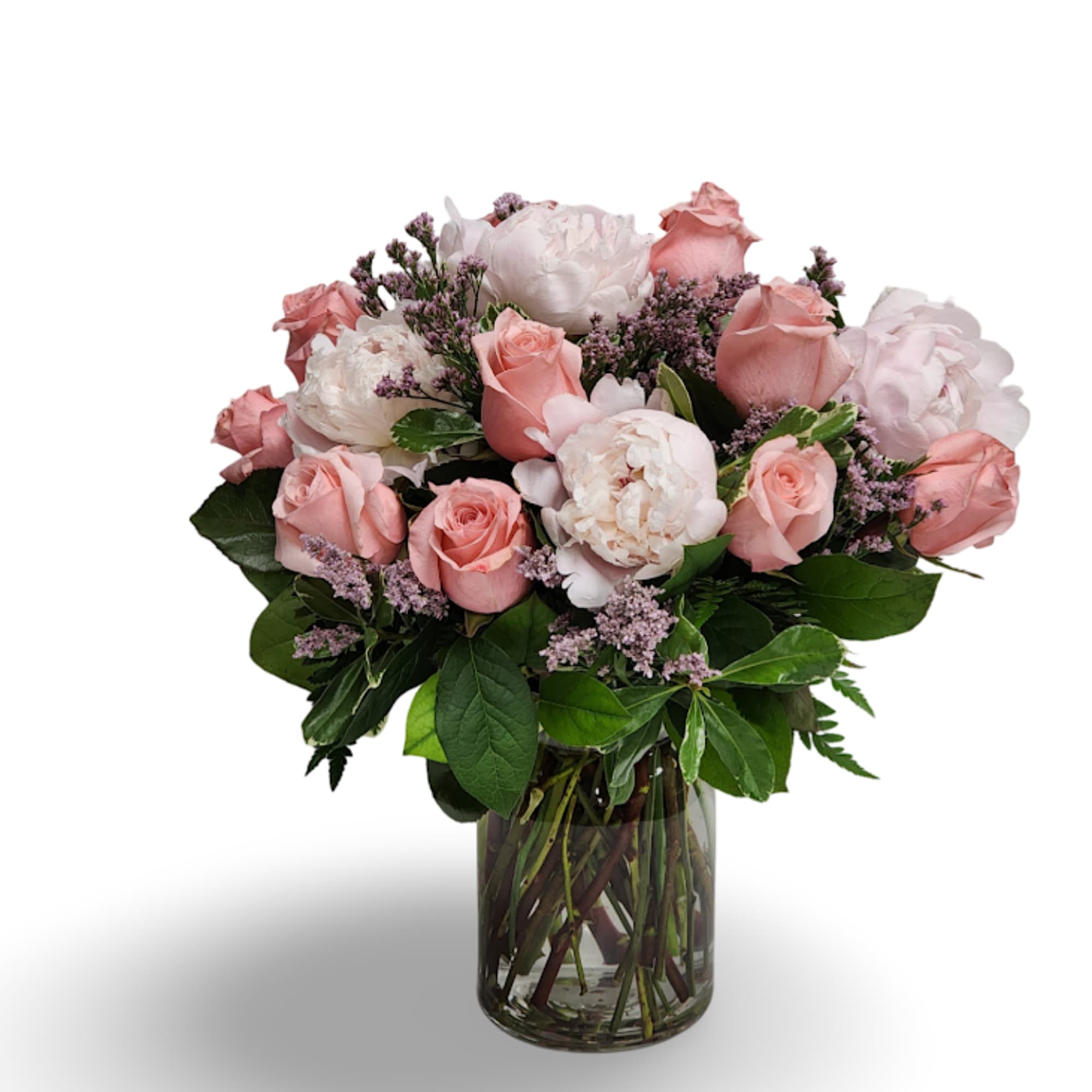 Pink roses and white peonies in a clear glass vase