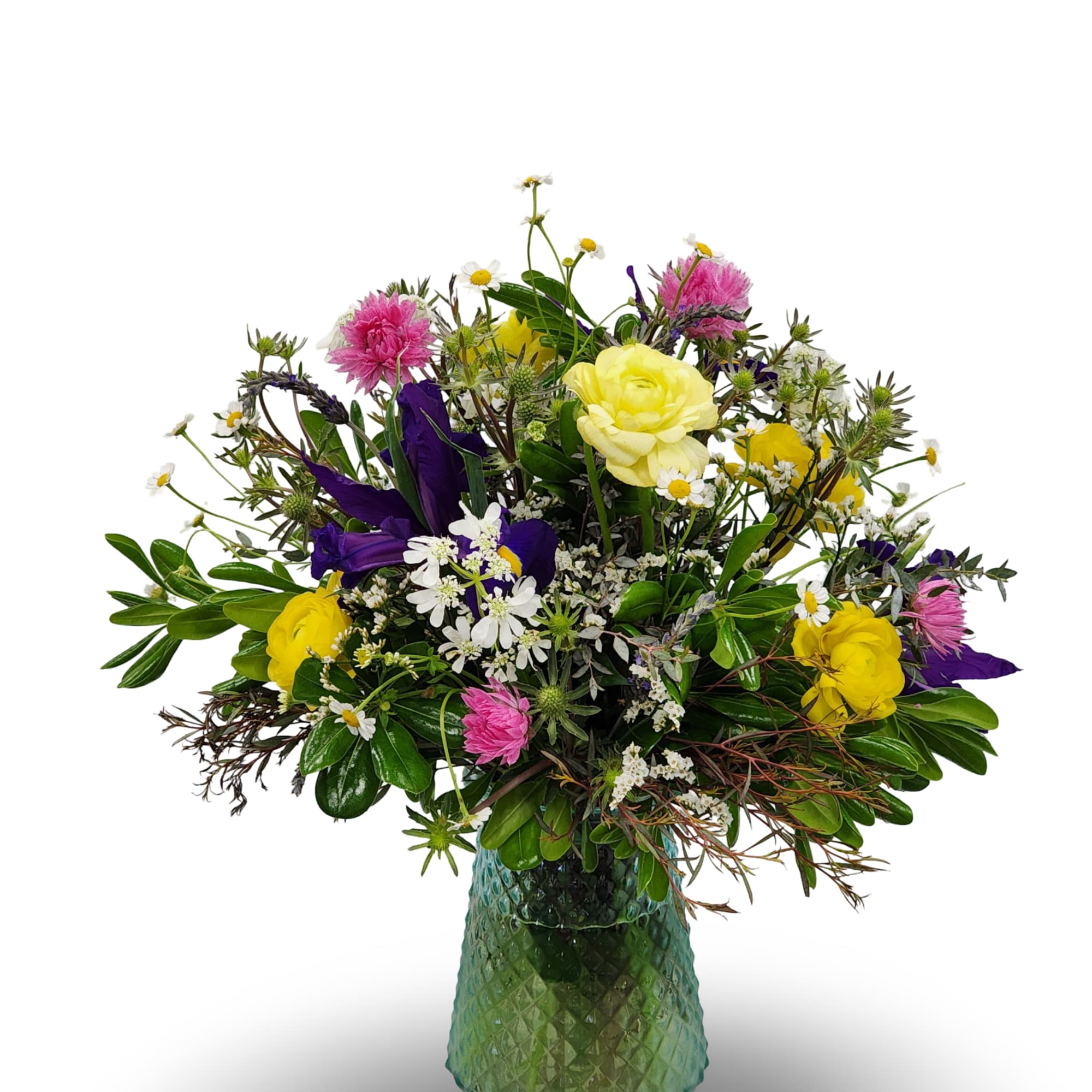 Mixed bouquet of yellow, pink, purple, and white flowers in a green glass vase