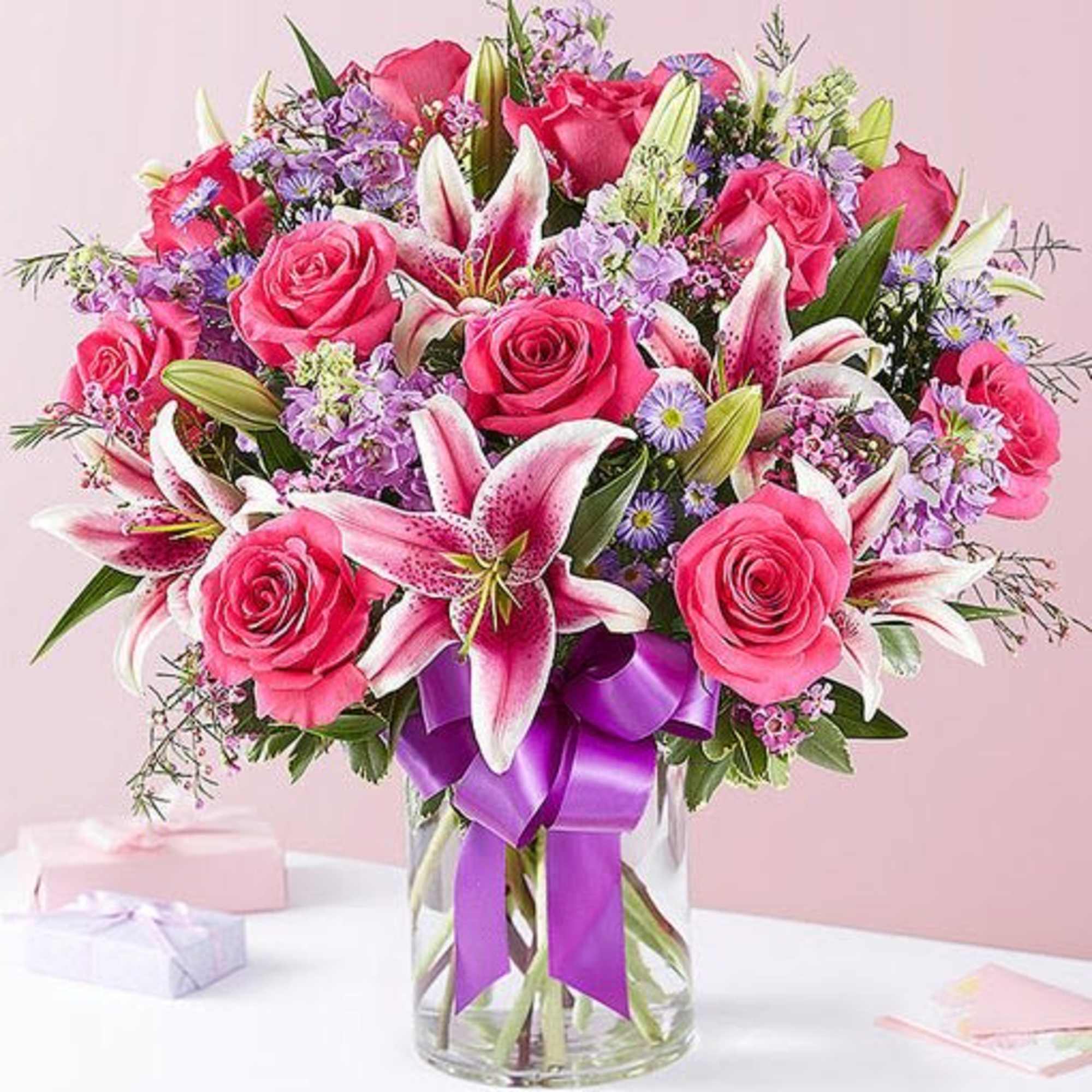 This arrangement with hot pink roses, pink Stargazer lilies, lavender stock, purple