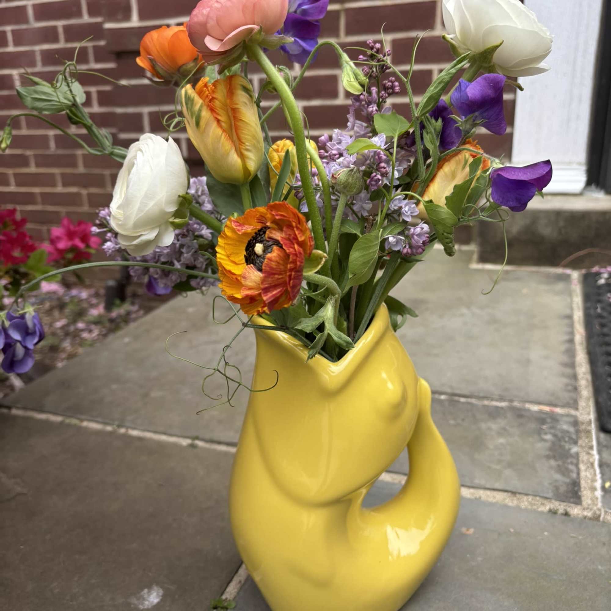 A colorful Gurgle Pot bursting with whimsical fresh local blooms.  The