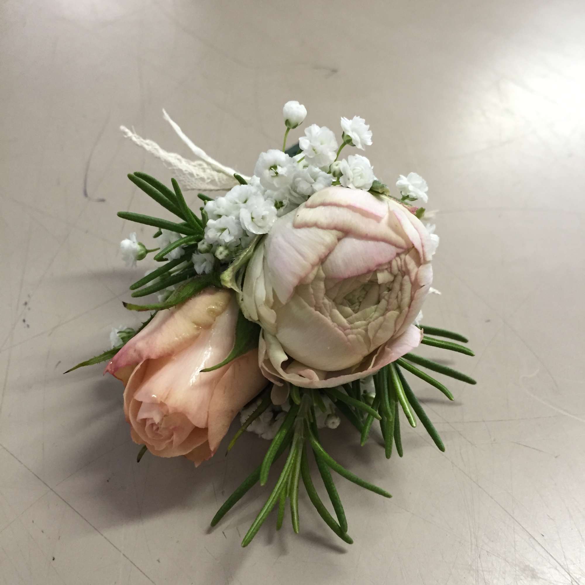 Small floral boutonniere with pale pink roses and white blooms