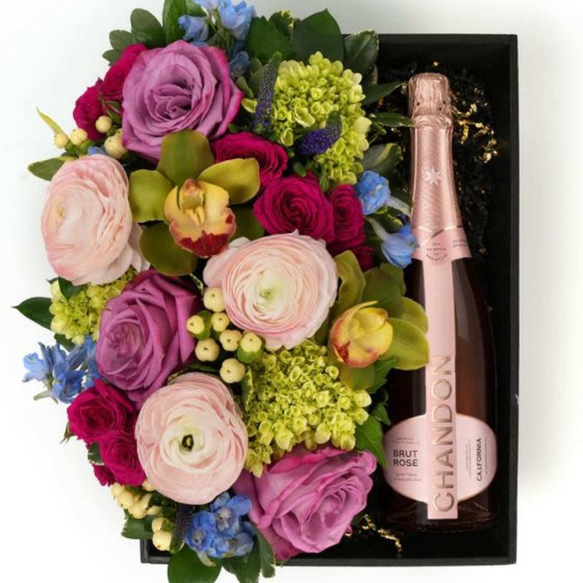 A pastel floral arrangement in a wood box paired with Chandon Rose'