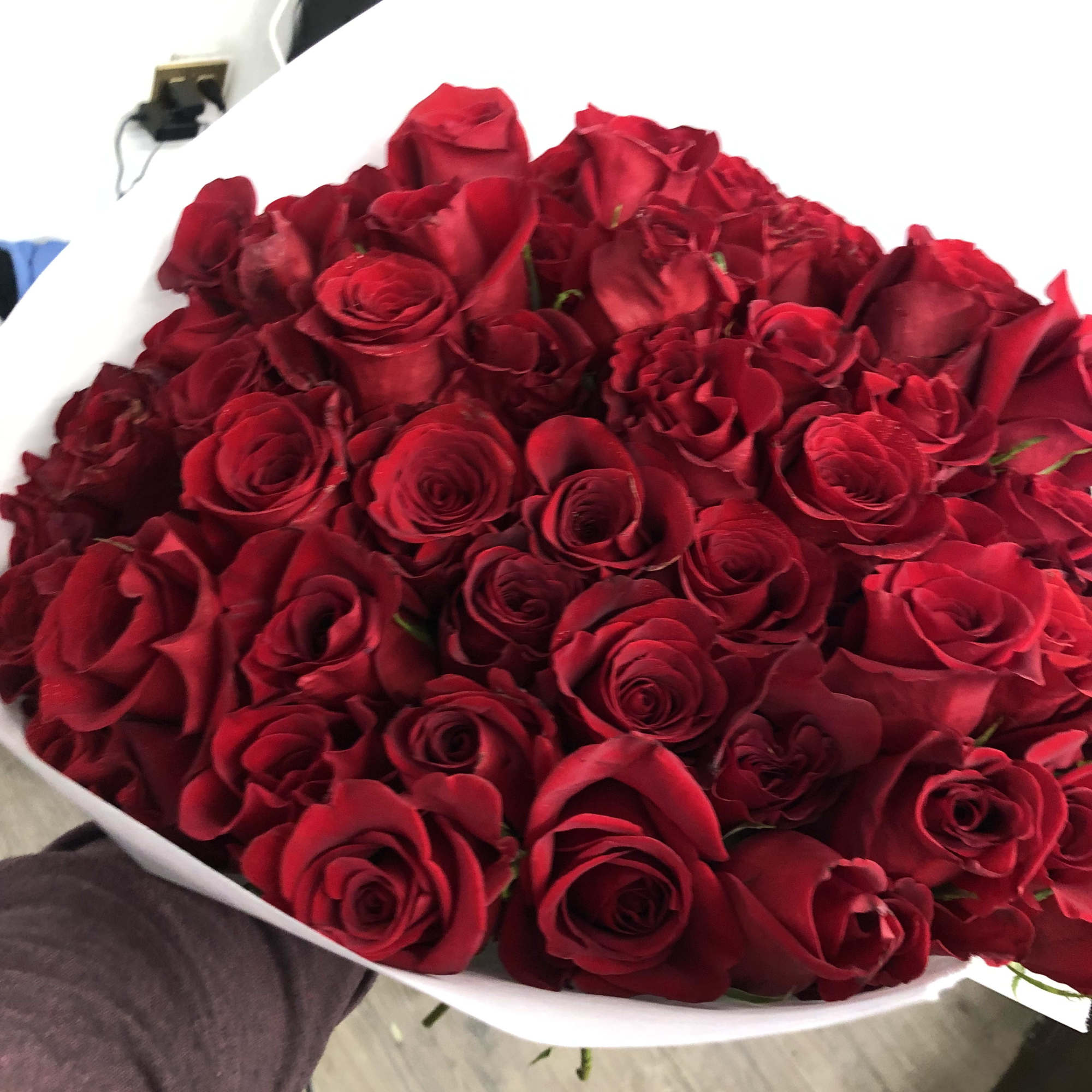 Large bouquet of red roses wrapped in white paper