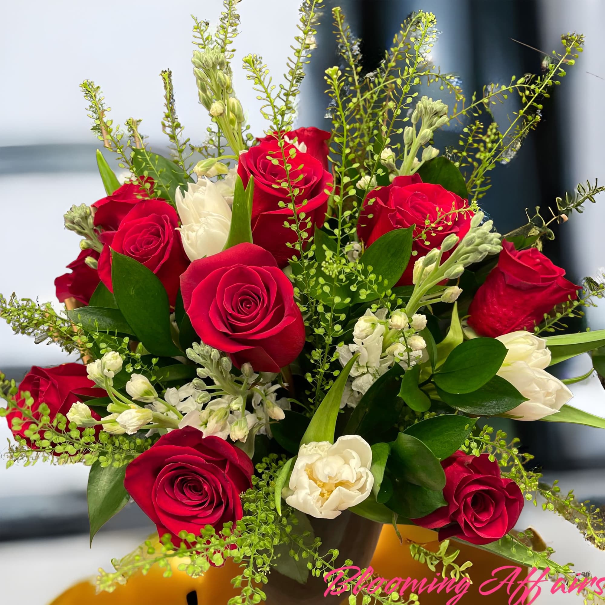 Bouquet of red roses and white flowers with greenery