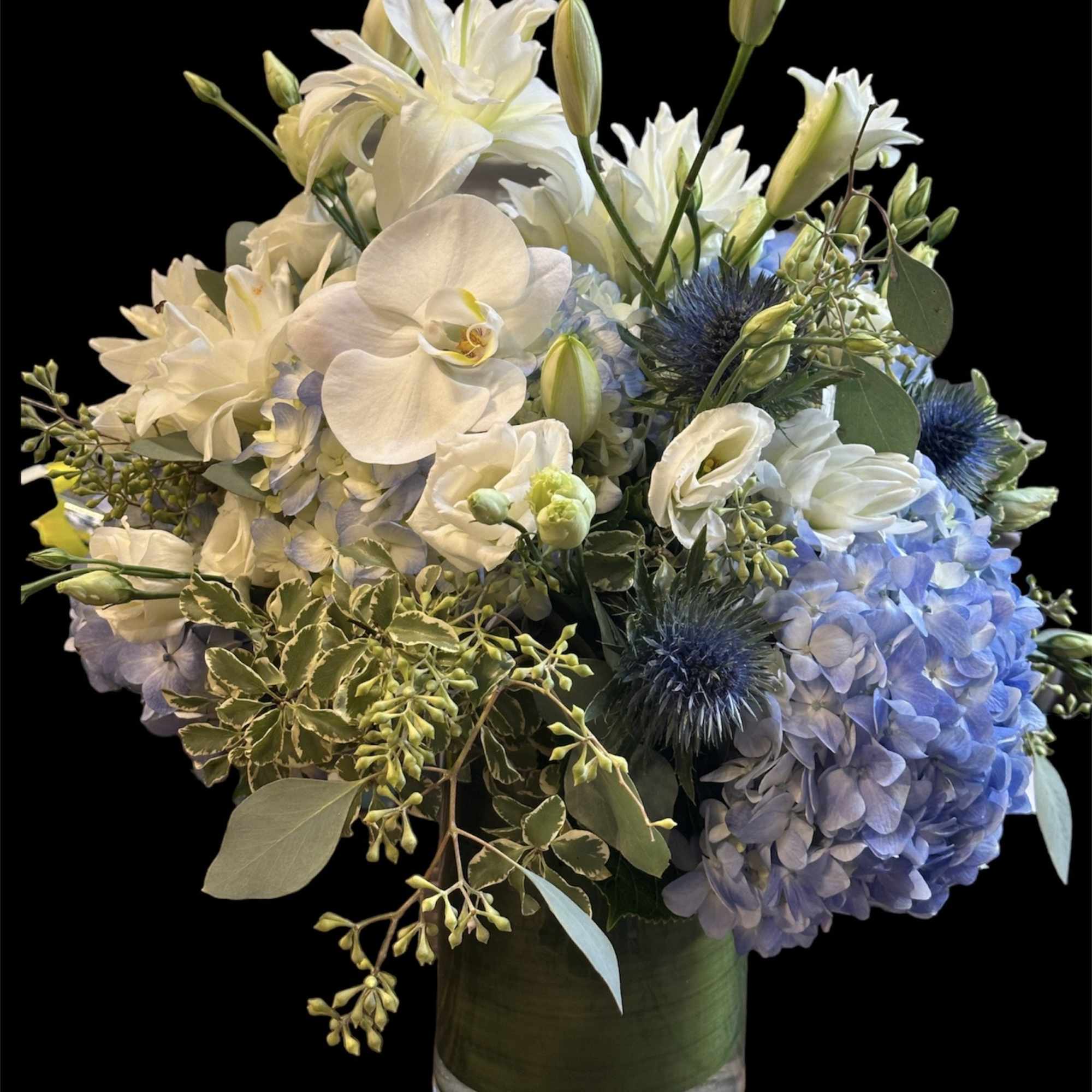 White and blue floral arrangement in a glass vase