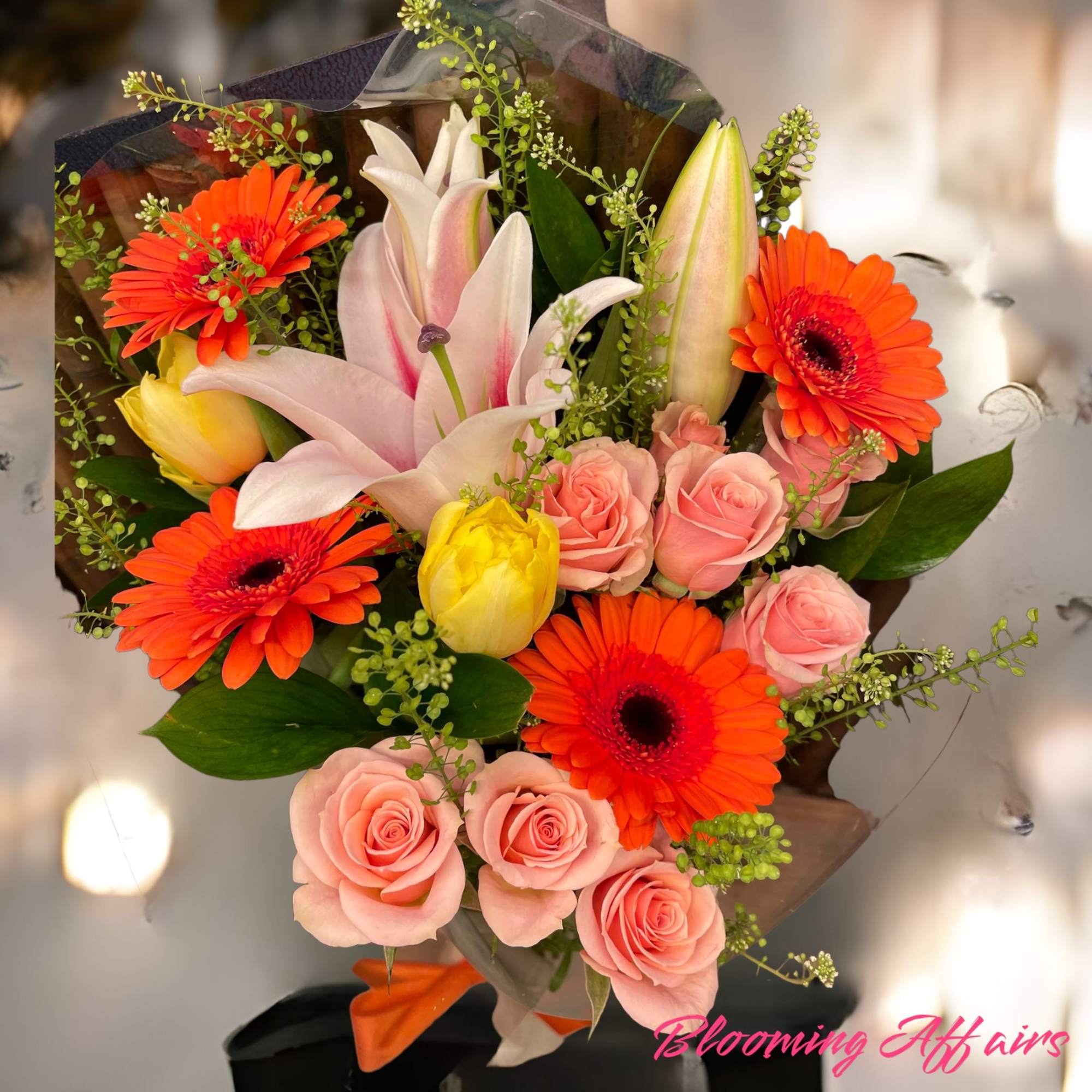 Bouquet of pink roses, orange gerbera daisies, and lilies
