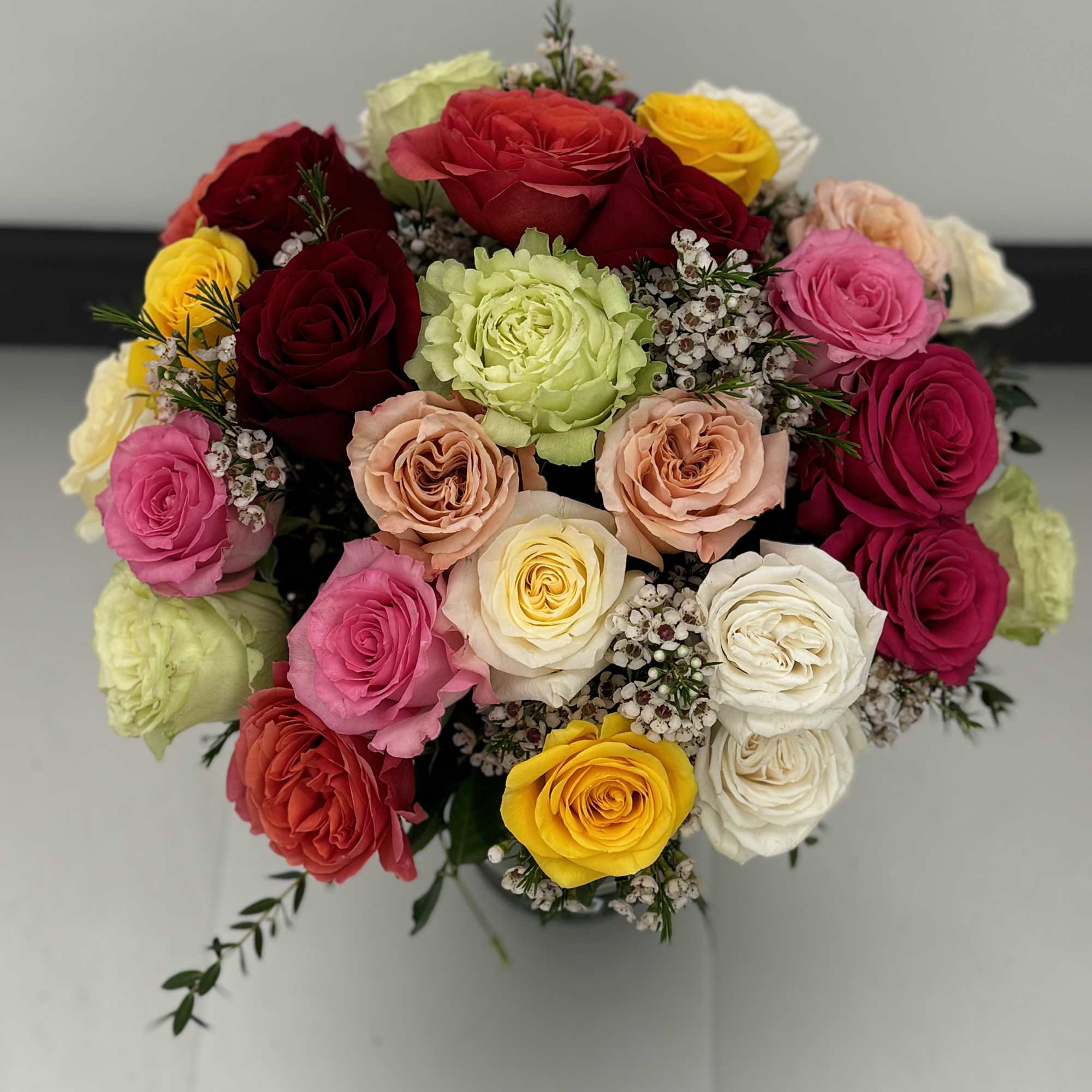 Mixed bouquet of colorful roses in a vase
