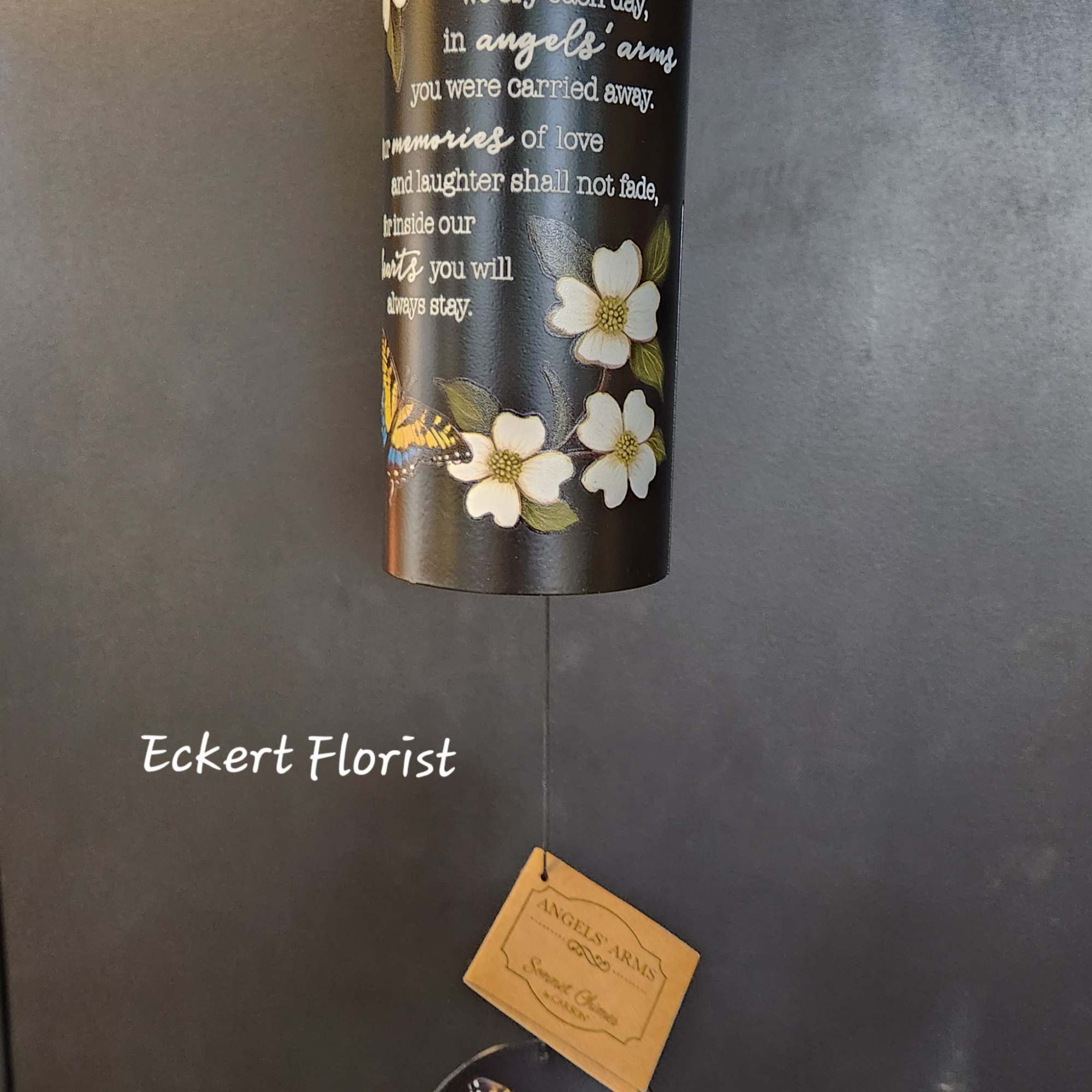 Black memorial wind chime with white flowers and a butterfly accent.