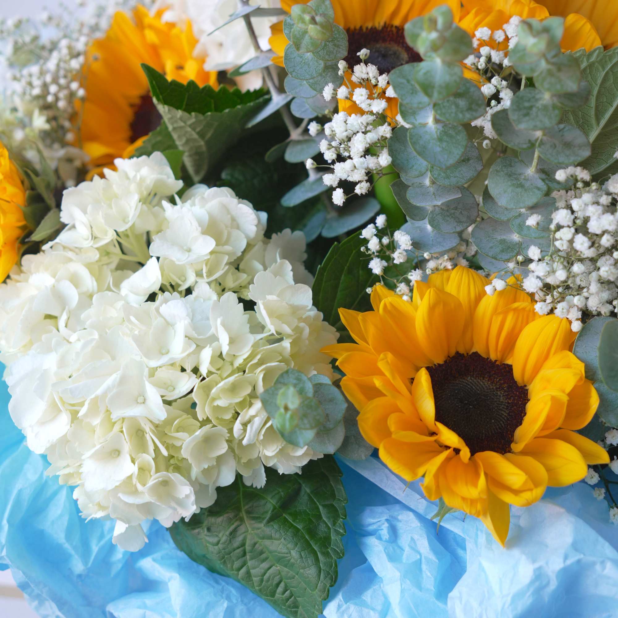 Bright sunflowers set a joyful tone in this sunflower and hydrangea bouquet-a
