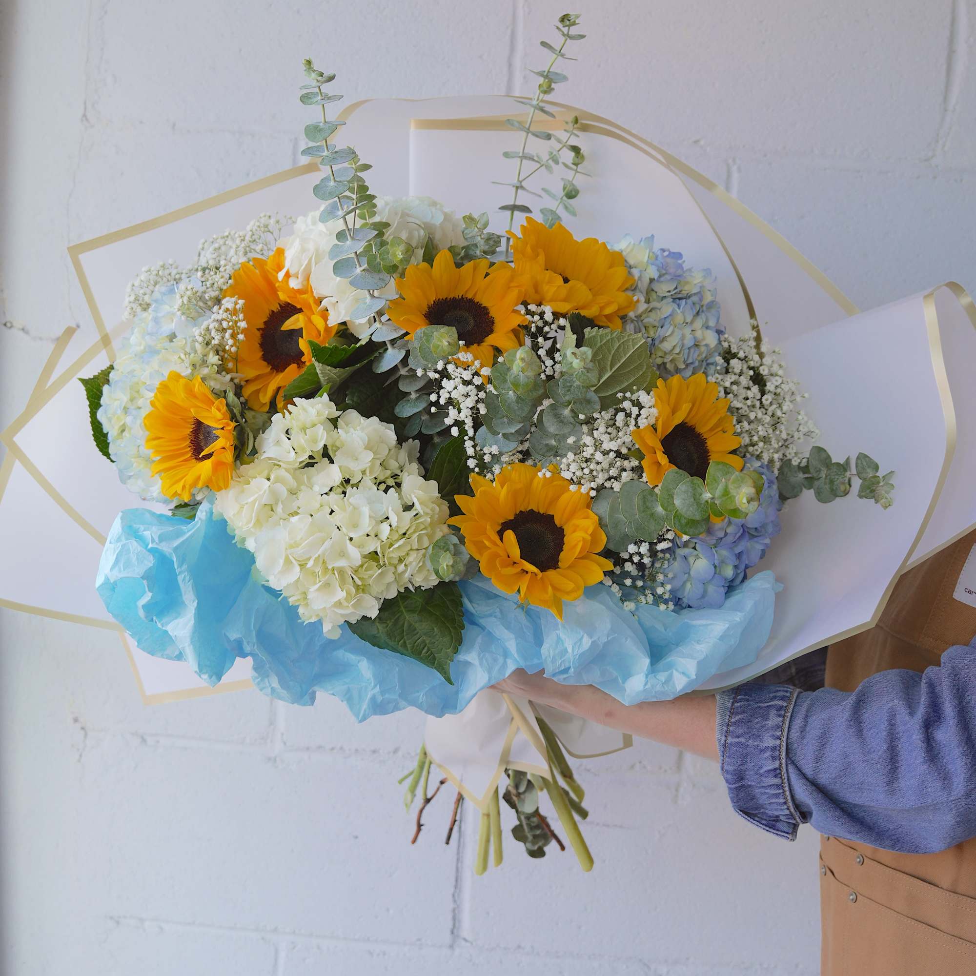 Bright sunflowers set a joyful tone in this sunflower and hydrangea bouquet-a