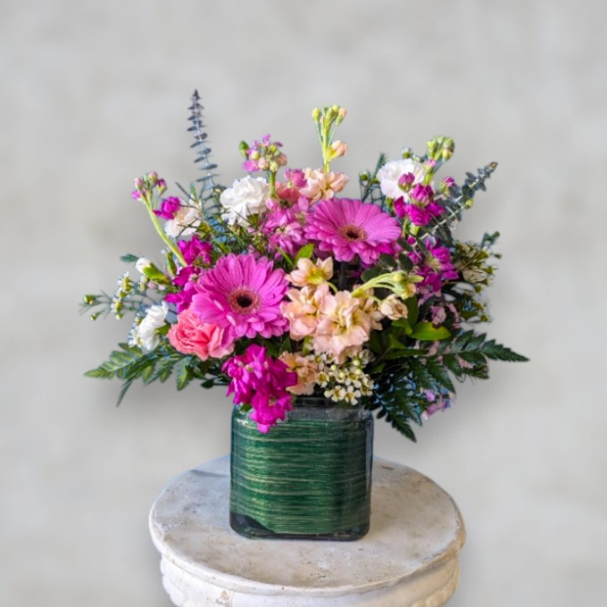 Bright magenta gerbera daisies and blush roses create an immediate "wow" -