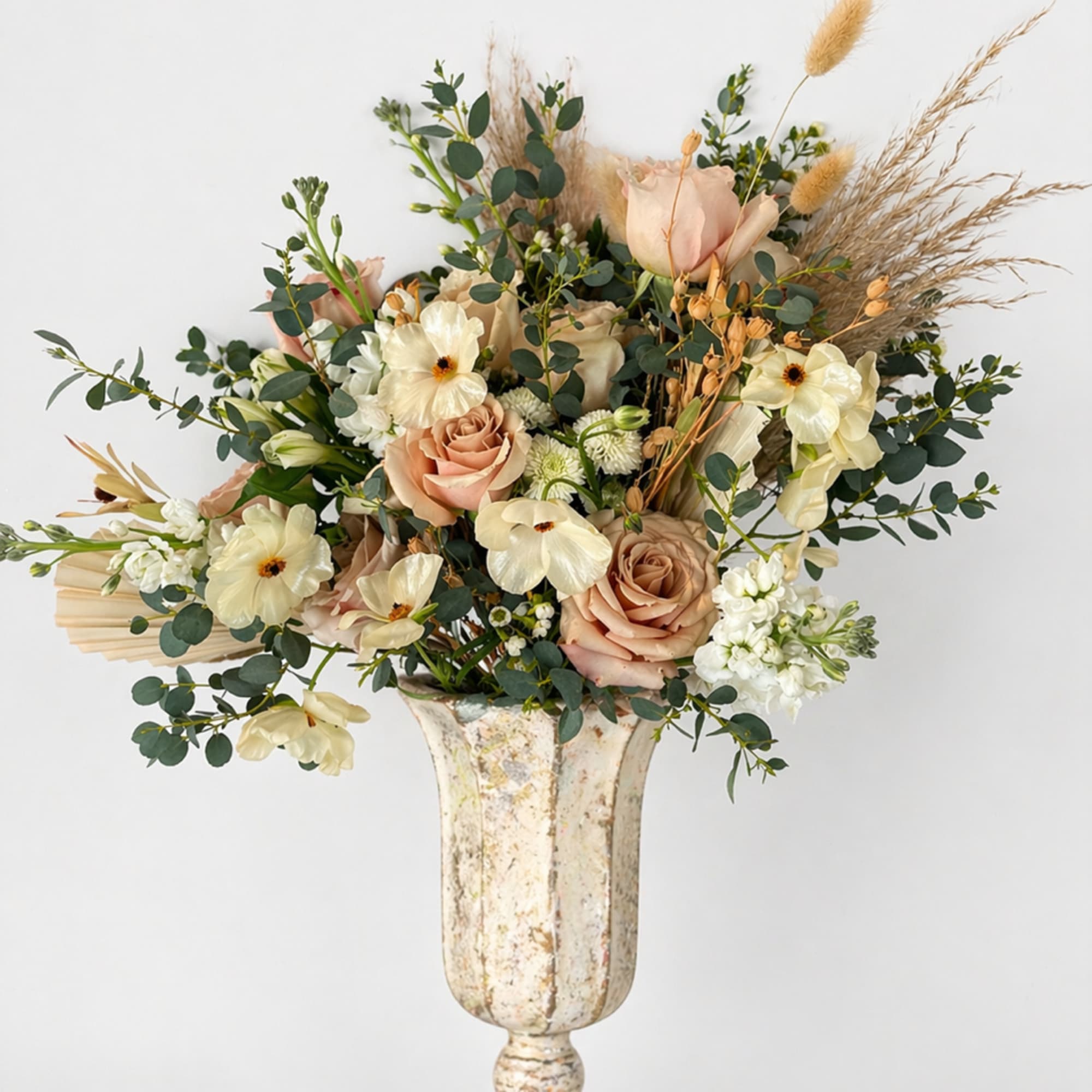 A mix of designer&rsquo;s choice blooms, in dusty pastels, tans and dried