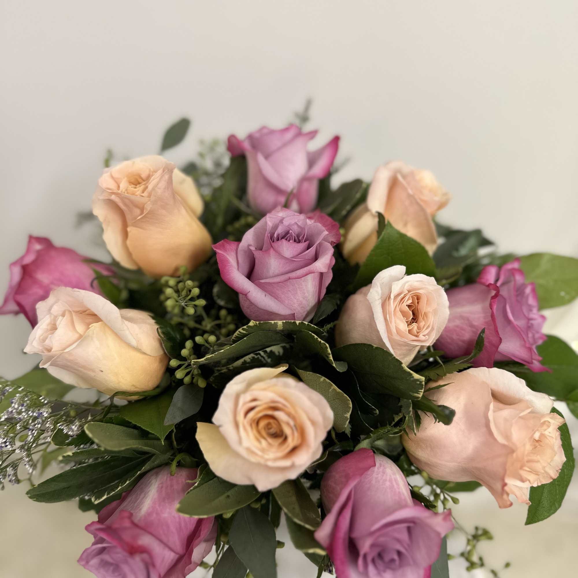 Bouquet of pink and peach roses with greenery