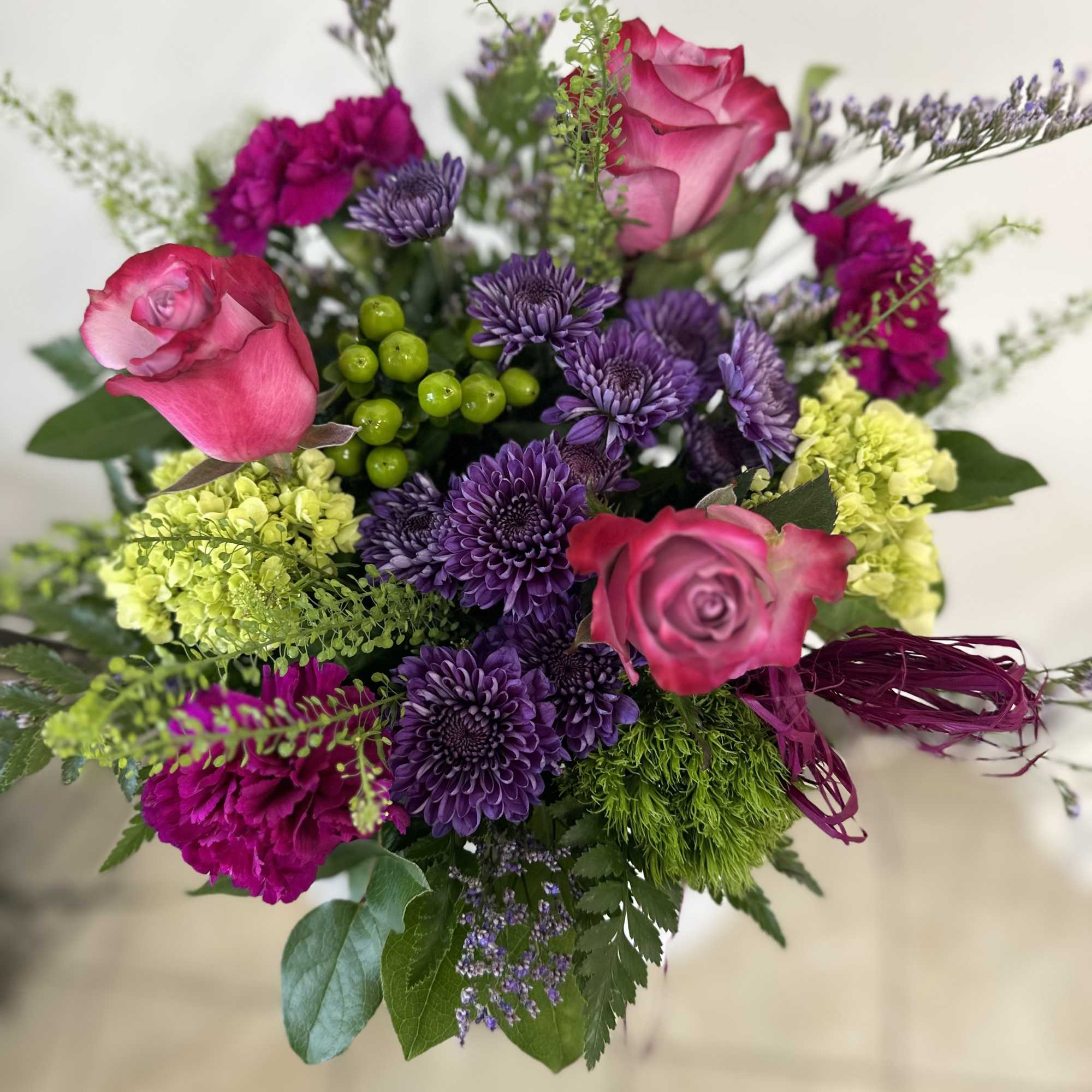 Bouquet of pink roses, purple chrysanthemums, and lime-green hydrangea