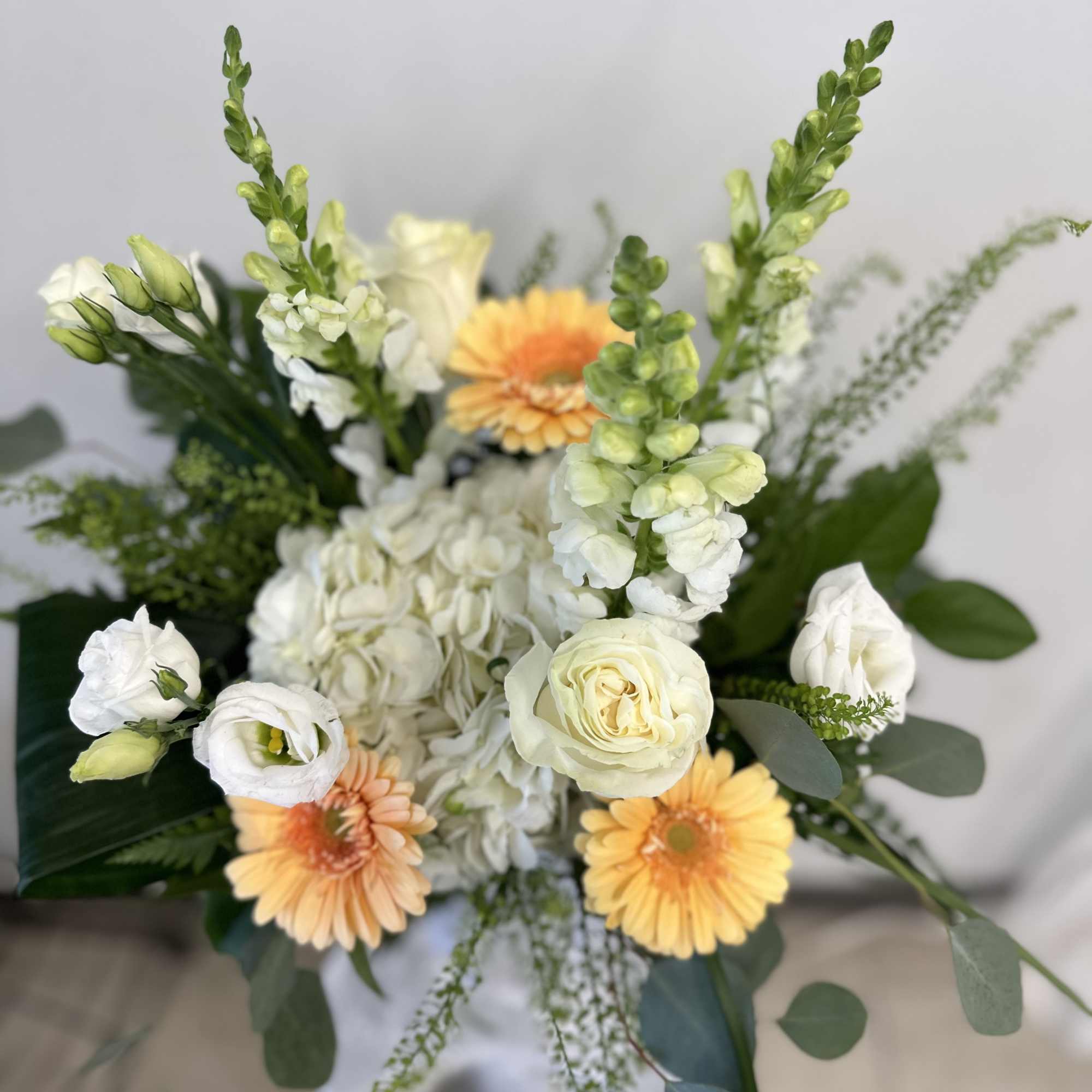 Bouquet of white and peach flowers with tall green spikes