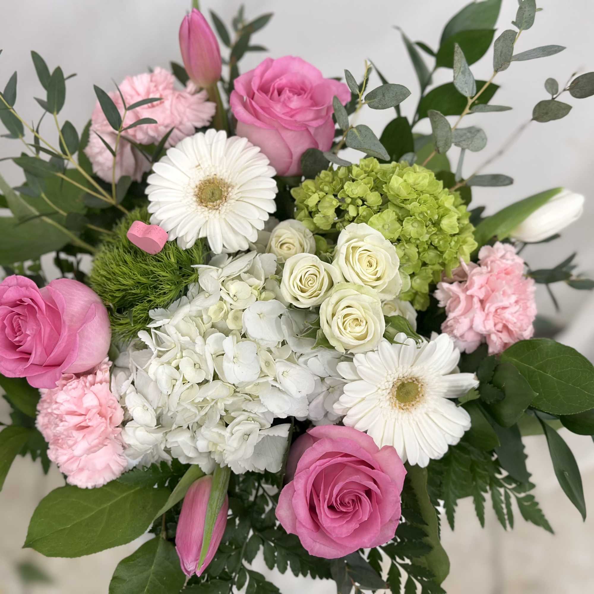 Bouquet of pink roses, white gerberas, and hydrangeas with green accents