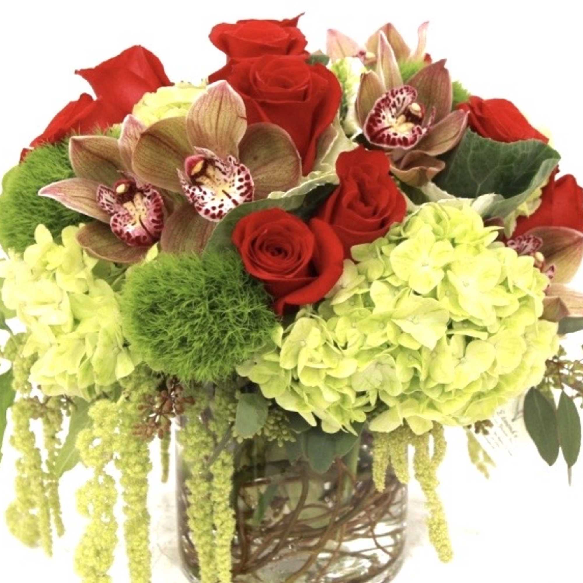 Bouquet of red roses, green hydrangeas, and orchids in a glass vase