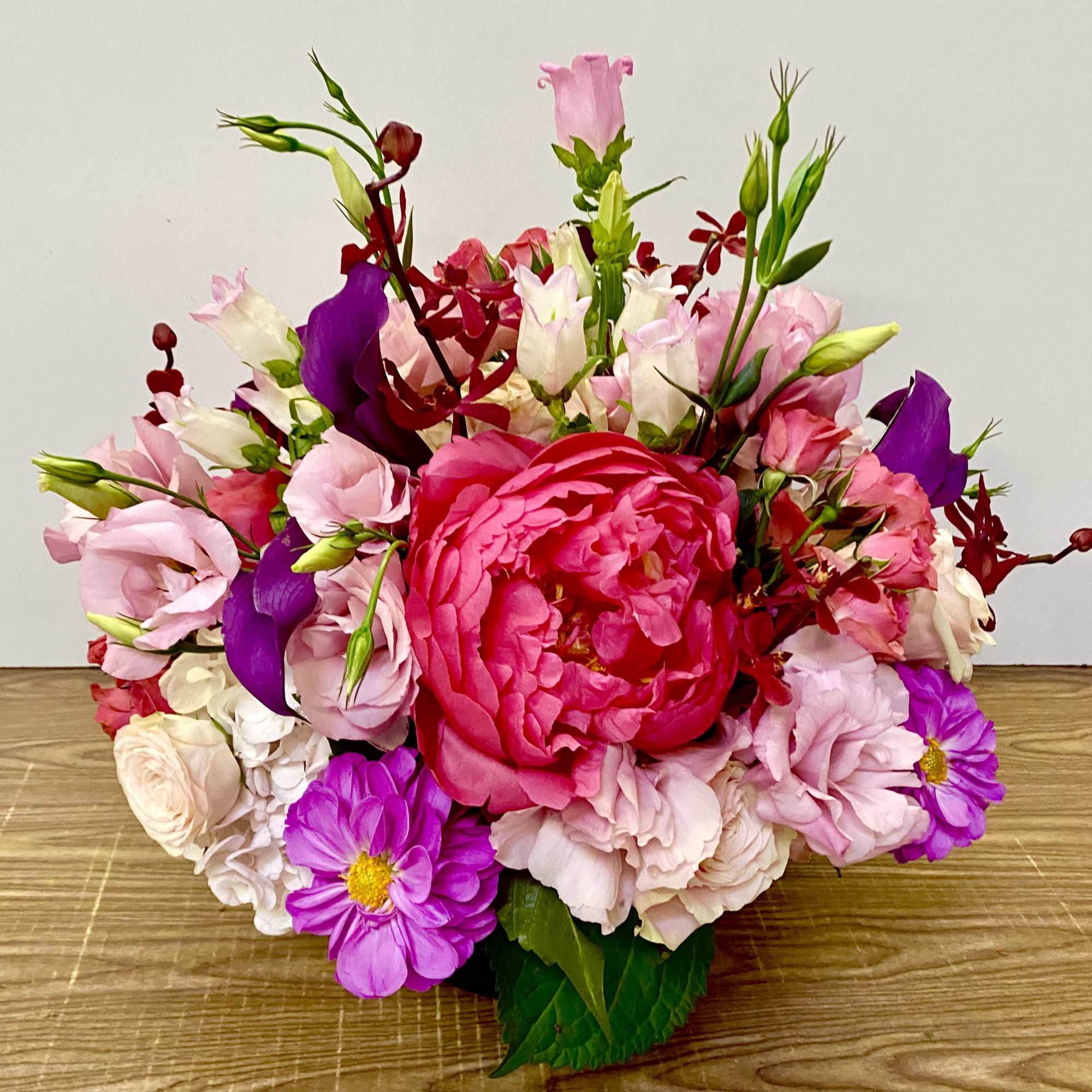 Mixed pink, purple, and white flower arrangement with a large central bloom