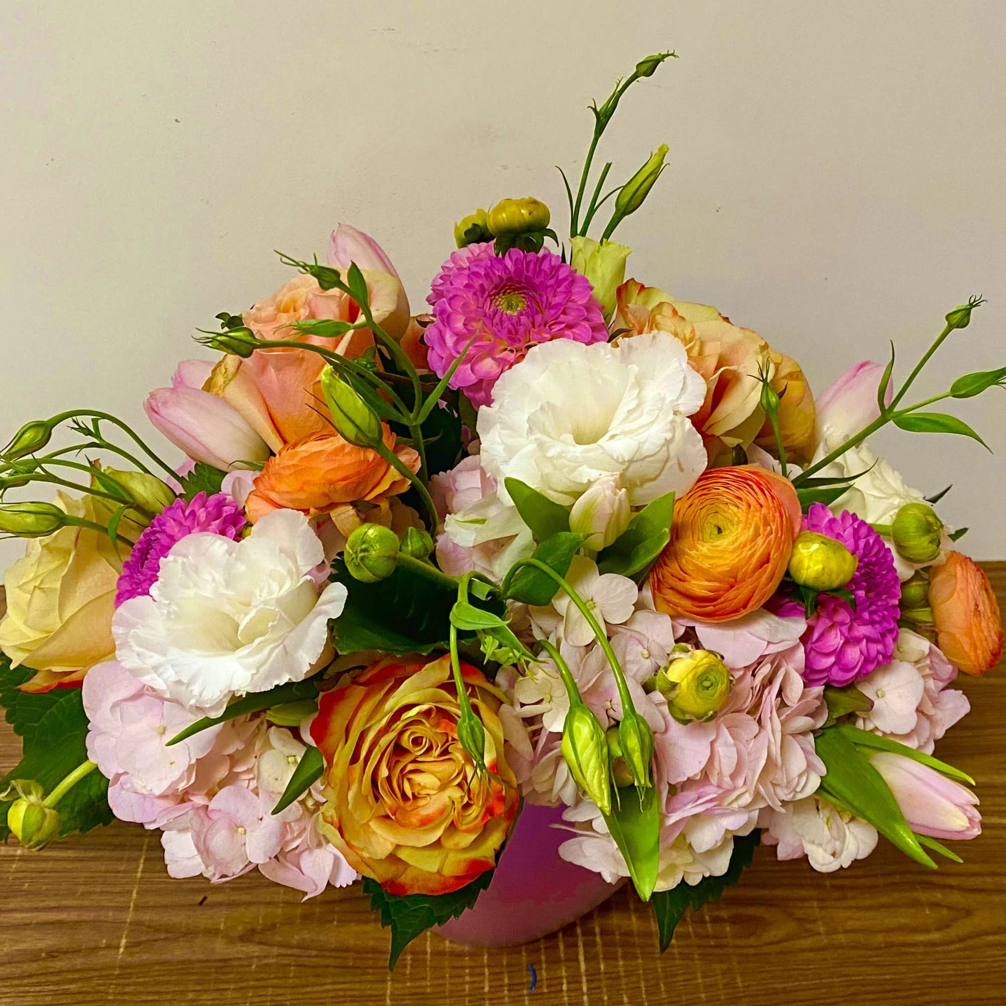 Mixed bouquet of pink, white, orange, and yellow flowers in a vase