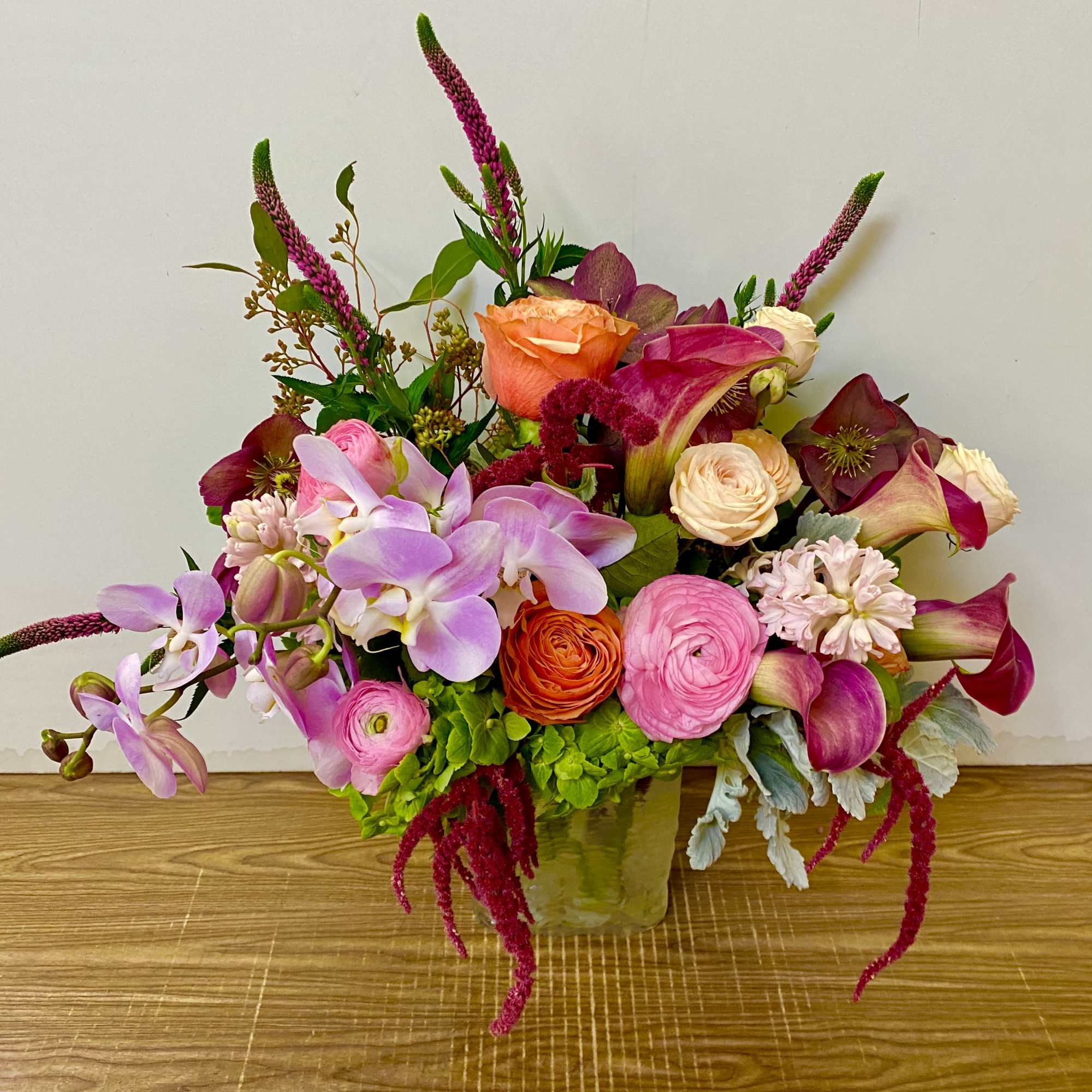 Mixed bouquet in a glass vase with pink, peach, and purple flowers