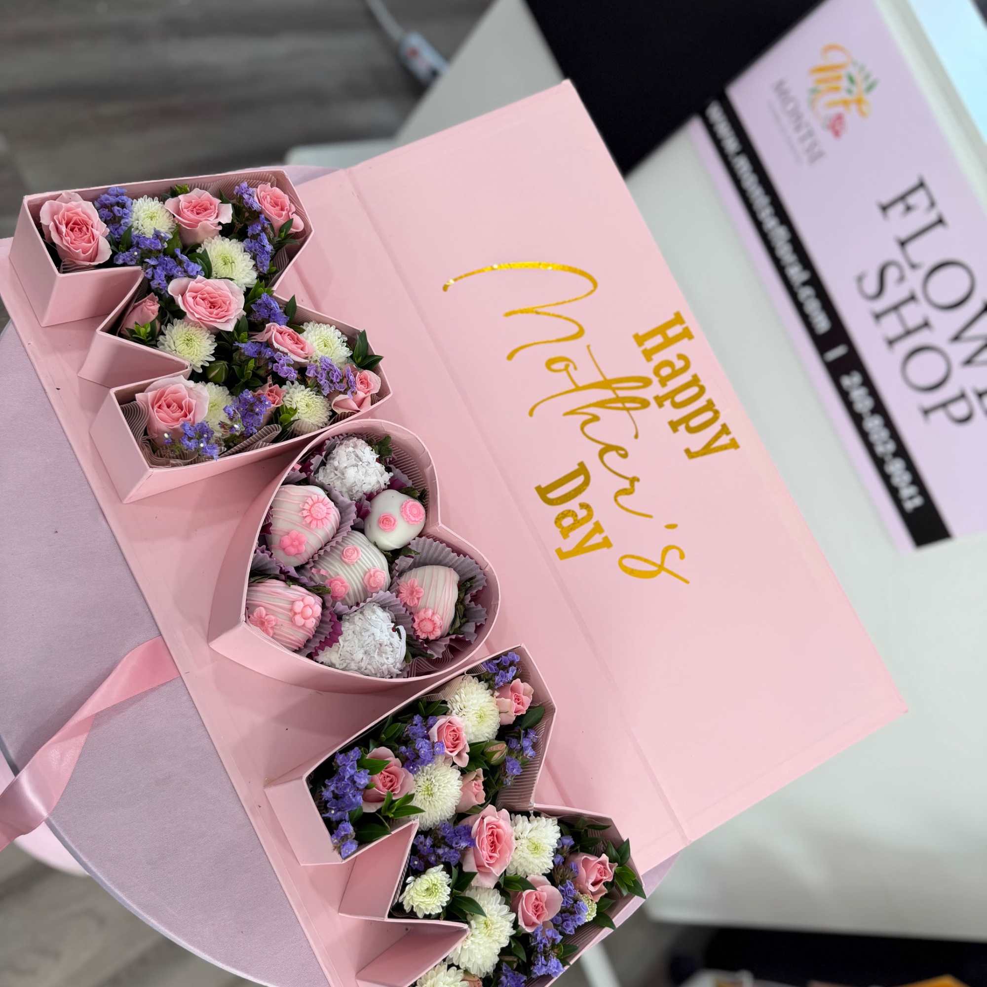 Heart-shaped pink box filled with pink spray roses, white mums, purple fillers