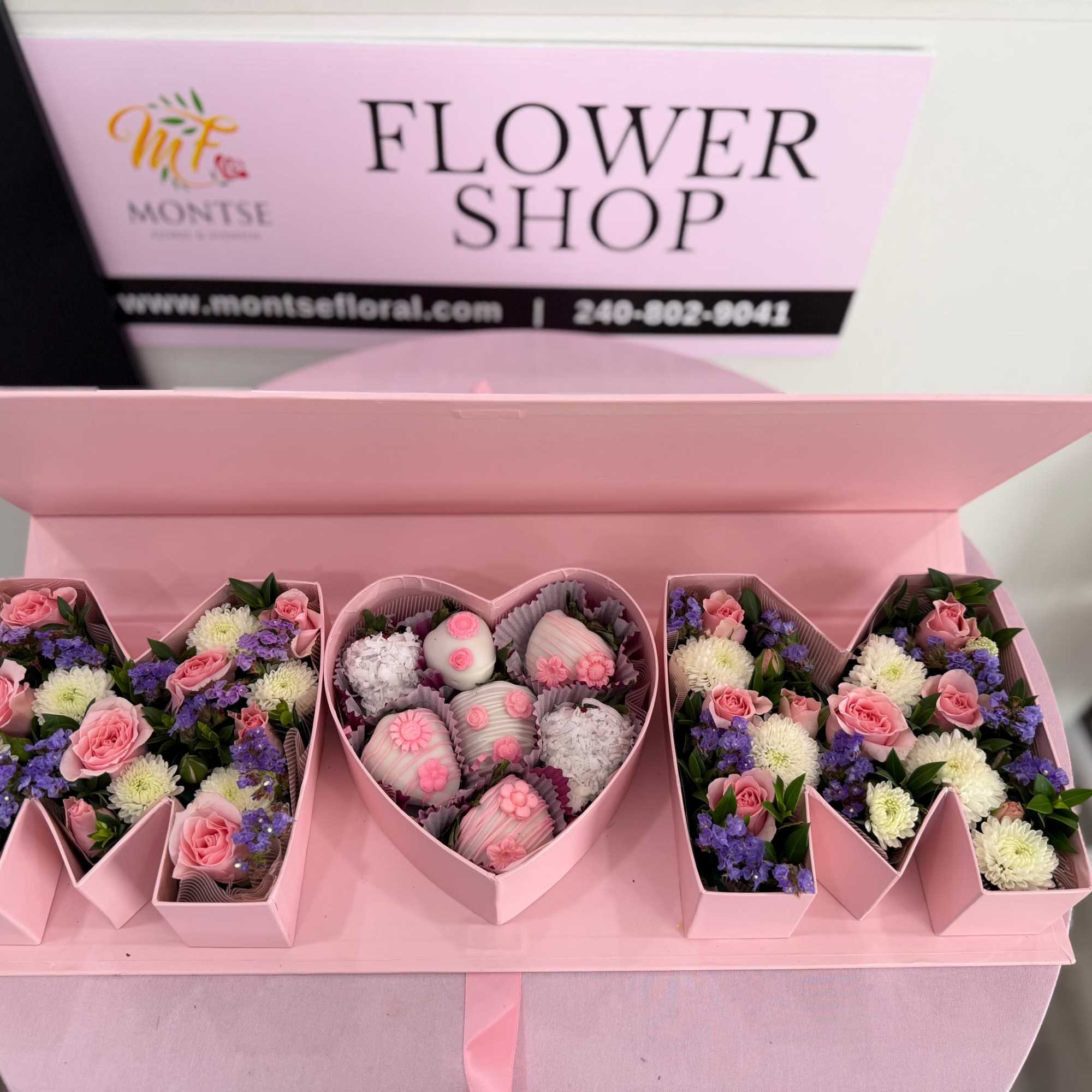 Heart-shaped pink box filled with pink spray roses, white mums, purple fillers