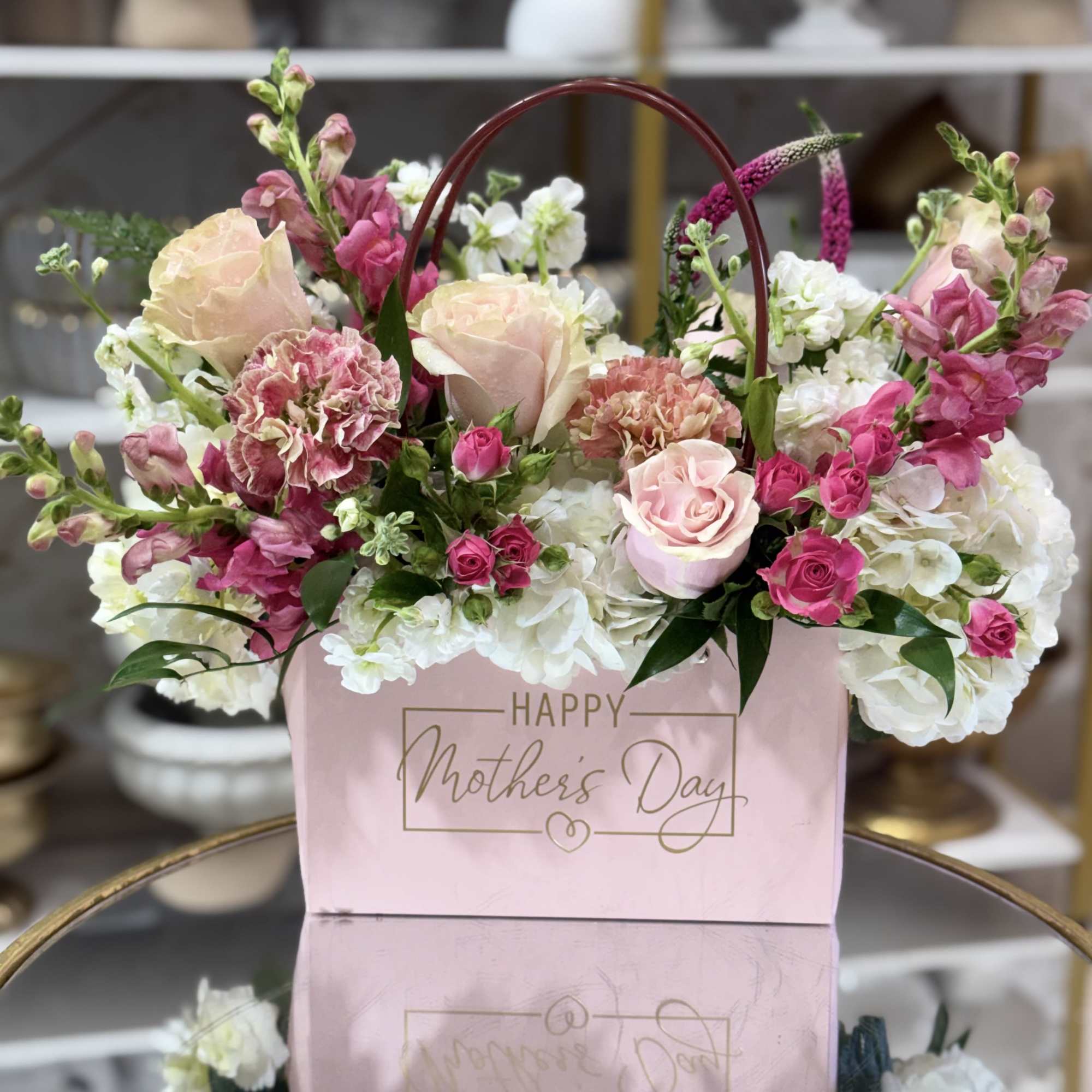 Soft blush roses and tall pink snapdragons rise above ruffled white hydrangeas
