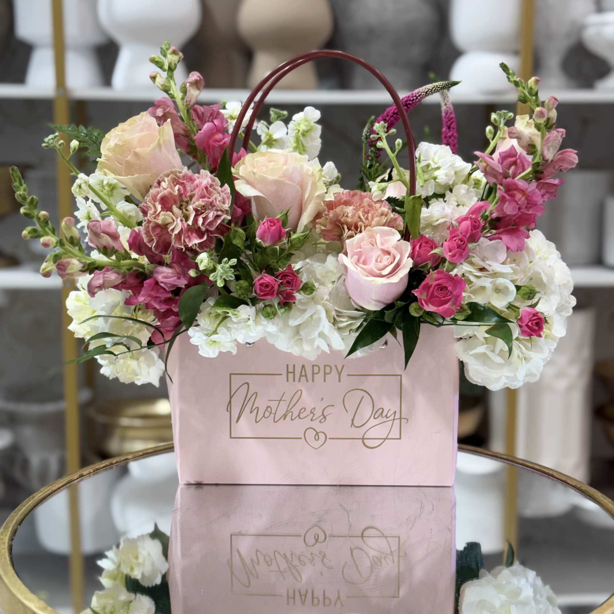 Soft blush roses and tall pink snapdragons rise above ruffled white hydrangeas