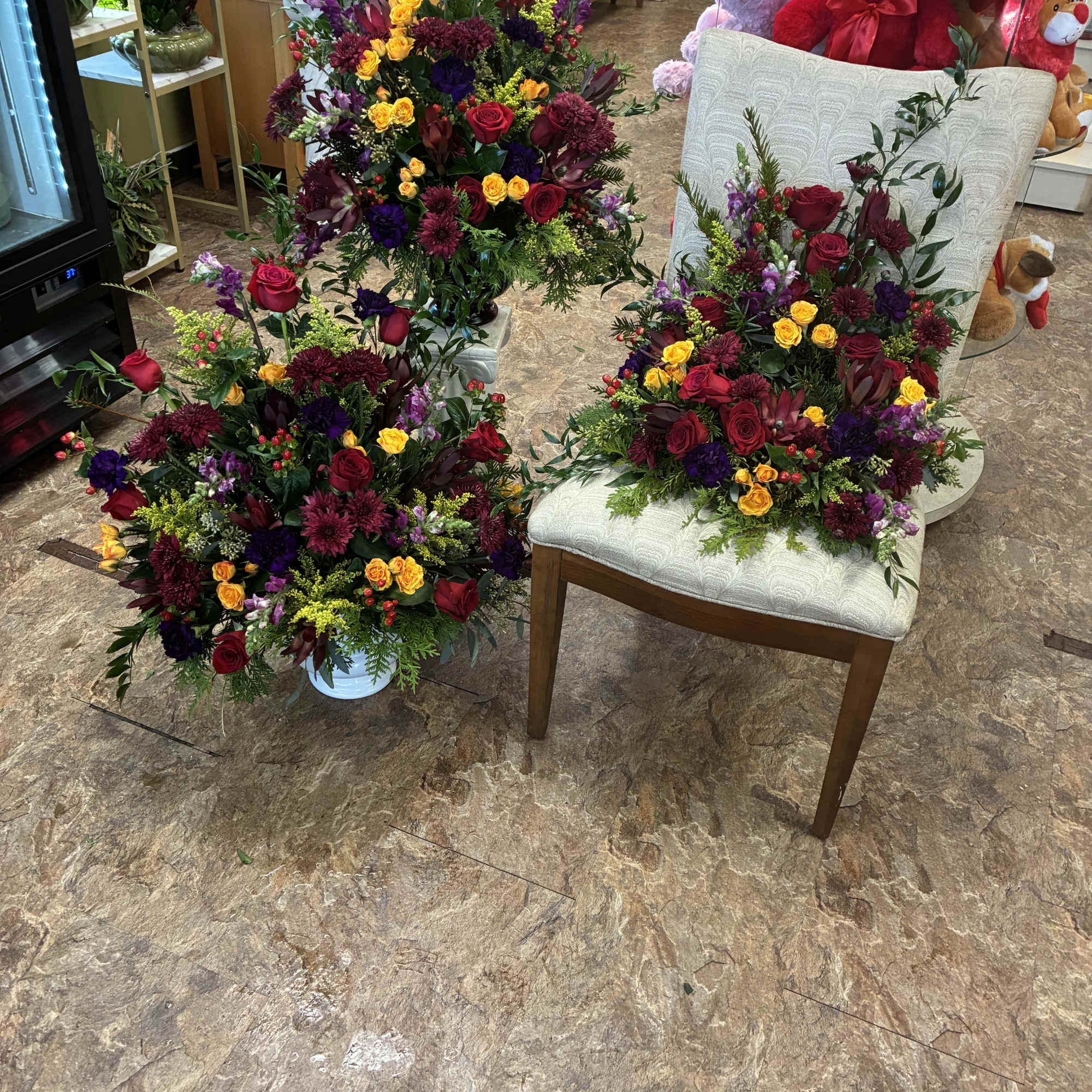 Three mixed floral arrangements with red, yellow, and purple blooms