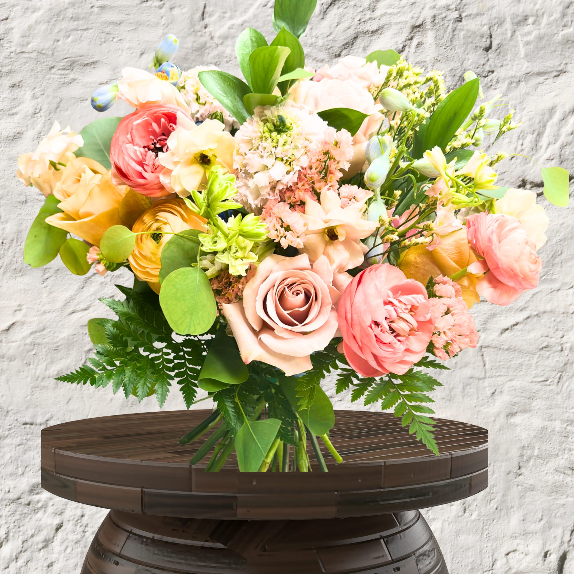 Bouquet of peach, pink, and yellow flowers with greenery