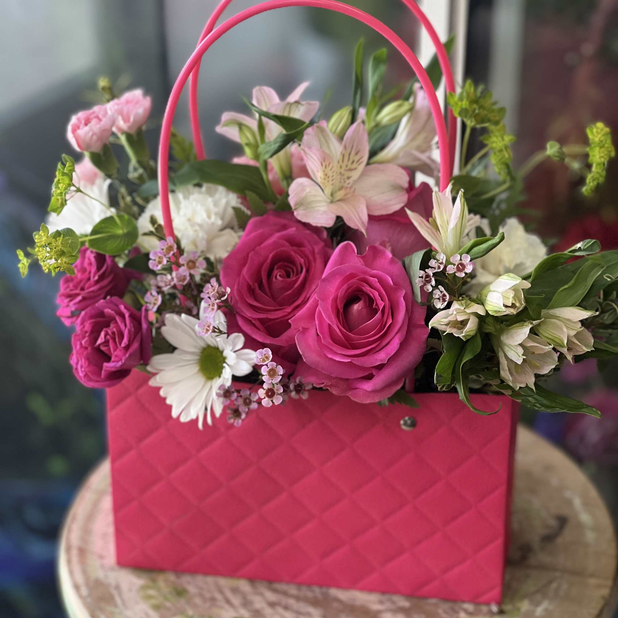 Pink rose bouquet in a bright pink handbag-style container