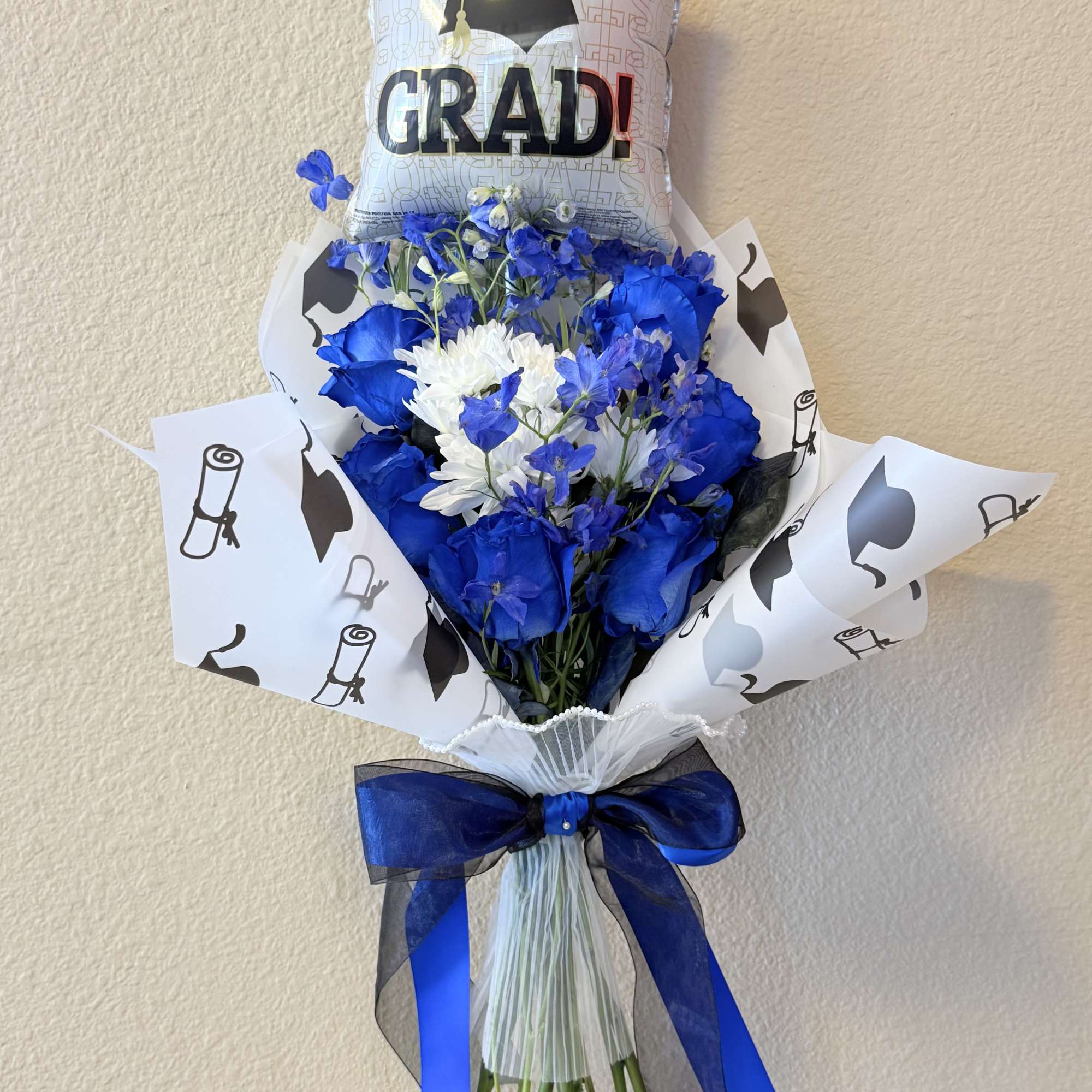 Vivid blue roses set a bold, celebratory tone in this graduation bouquet-perfect