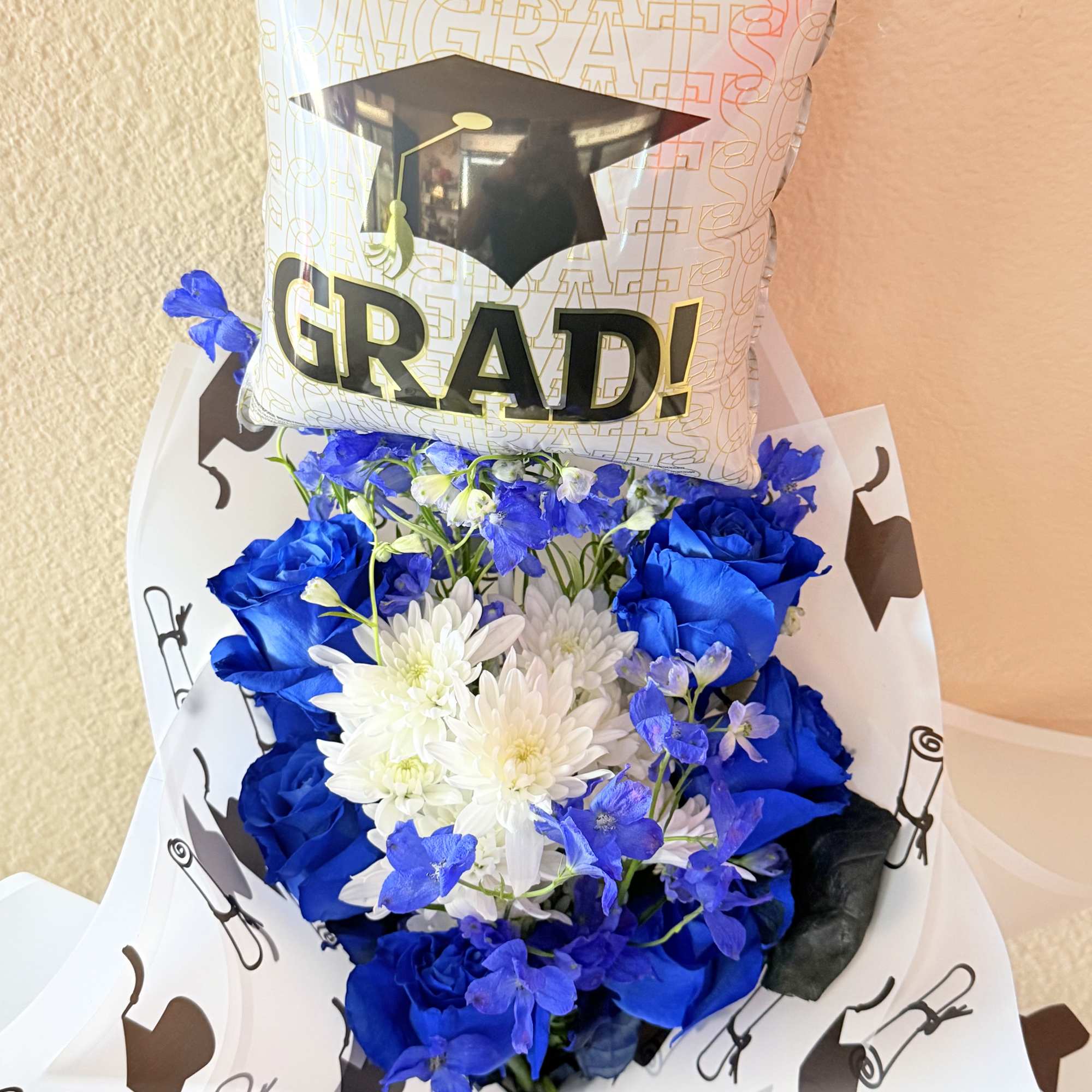 Vivid blue roses set a bold, celebratory tone in this graduation bouquet-perfect