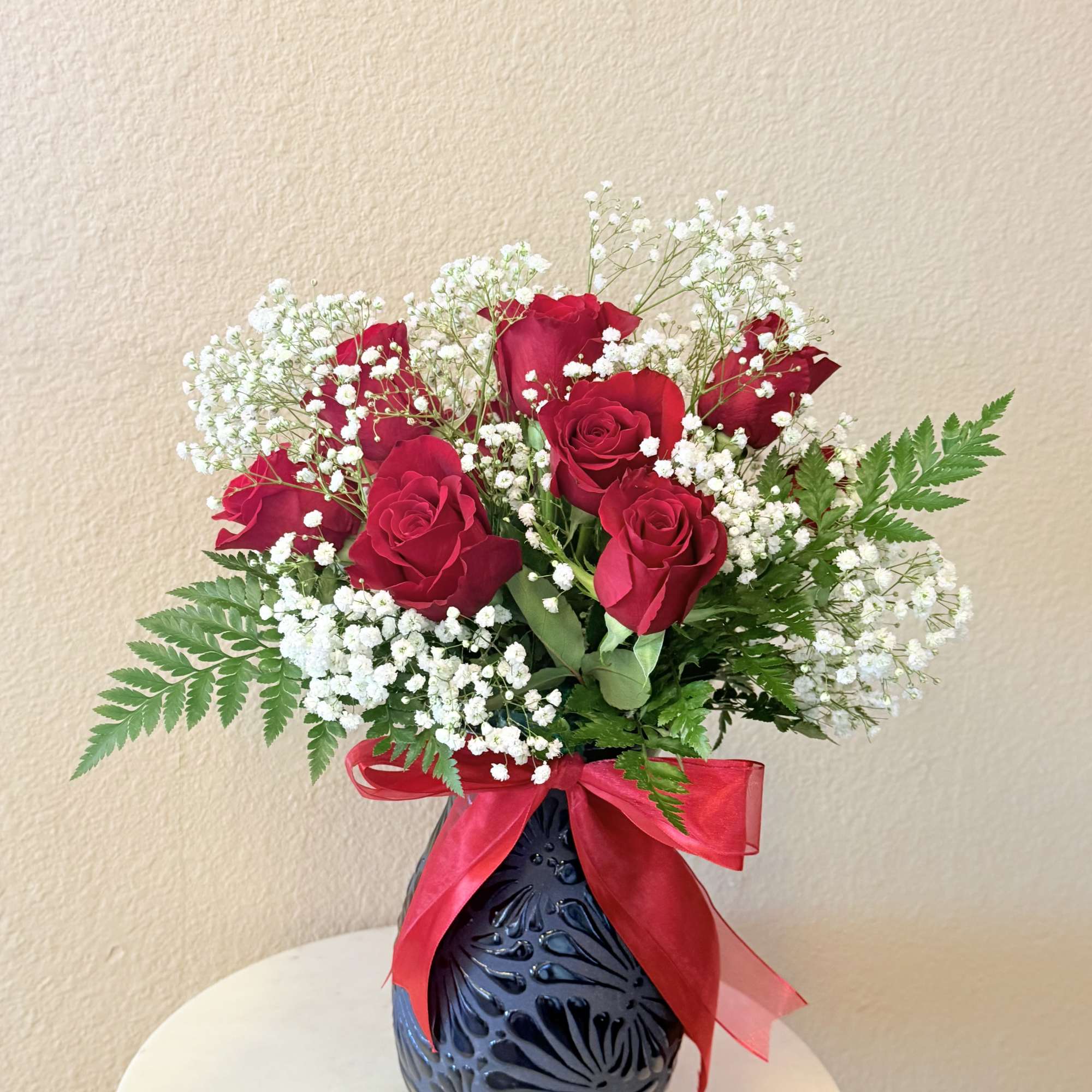Deep, velvety red roses clustered with clouds of white baby's breath create