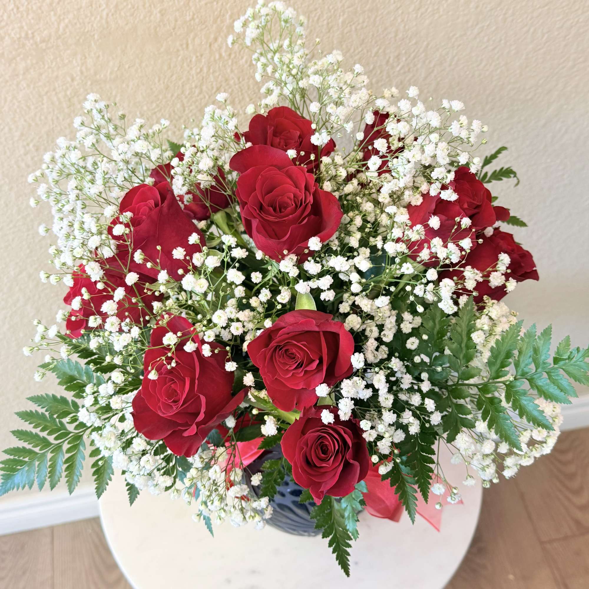 Deep, velvety red roses clustered with clouds of white baby's breath create