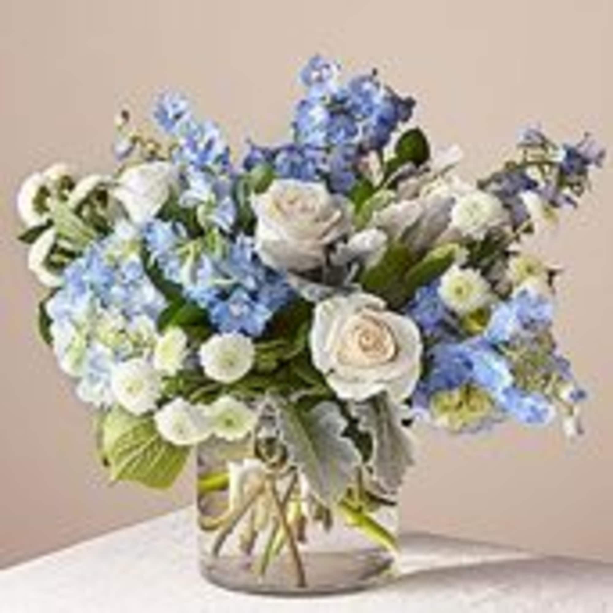 Soft blue delphinium spikes rising above a cloud of white roses give