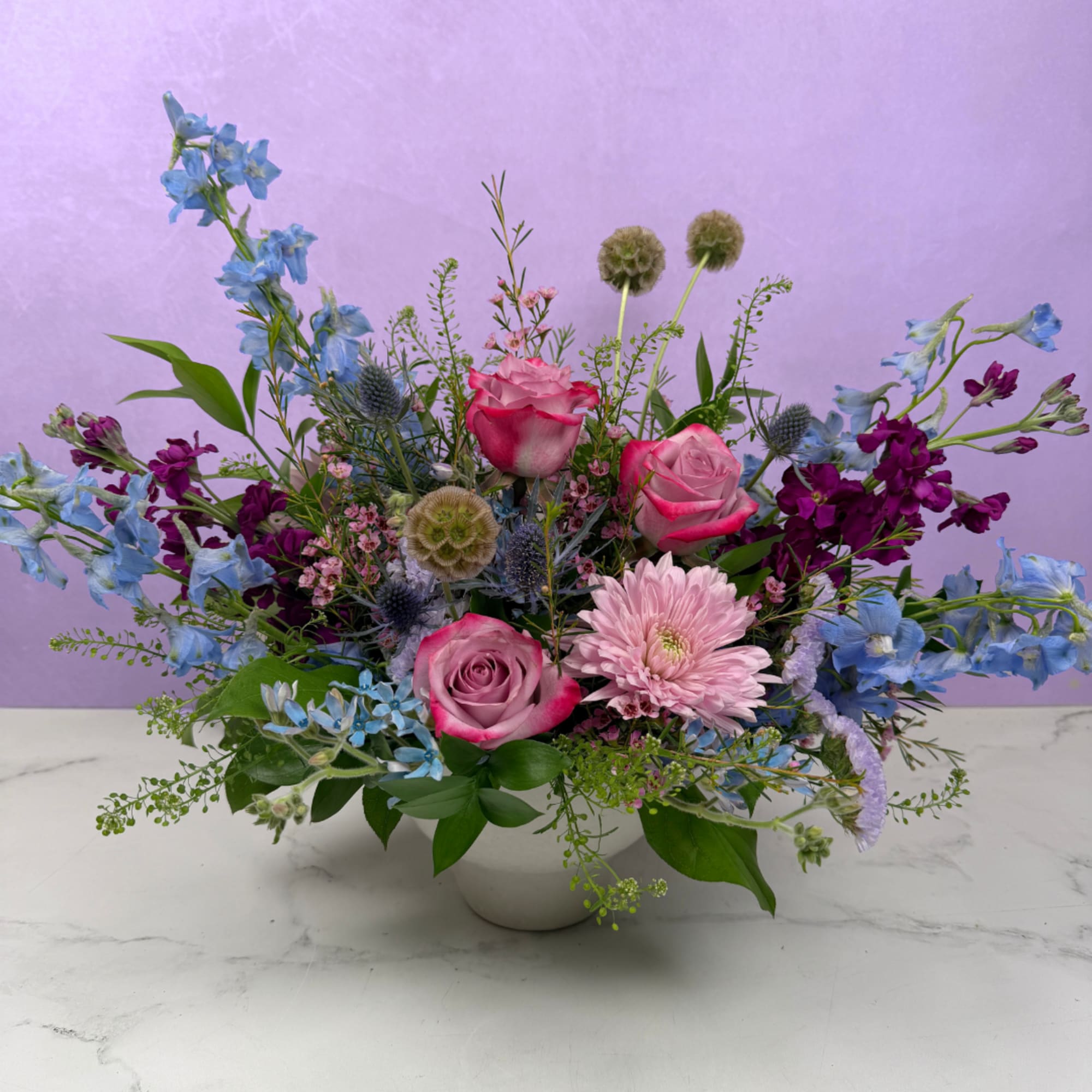 A lush, flowing arrangement of cool-toned blooms designed to feel peaceful and
