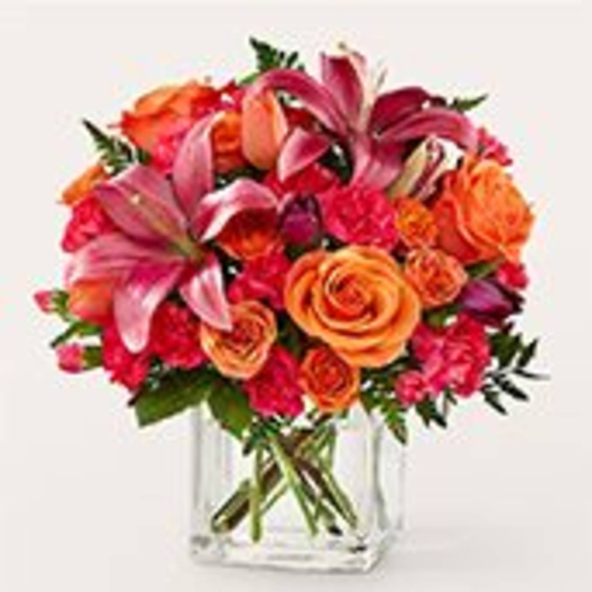 A dazzling cluster of pink lilies and vibrant orange roses makes a